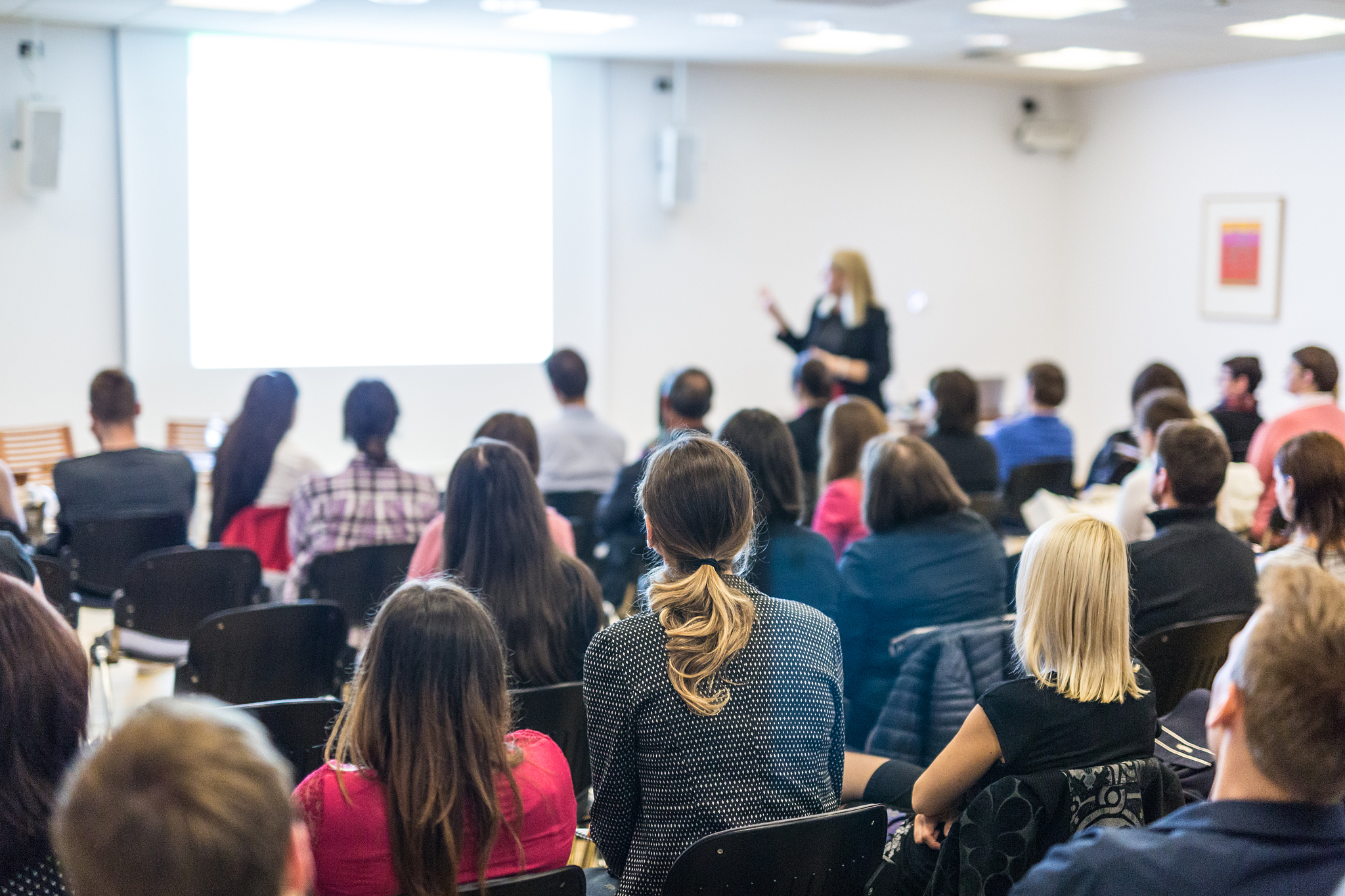 woman giving presentation on business conference workshop.