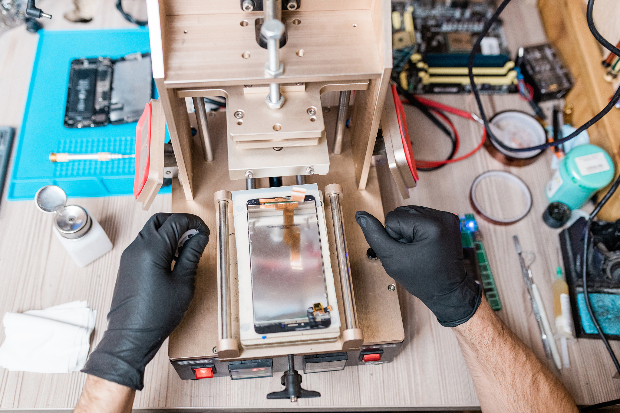 gloved hands of professional repairman using equipment for gadge