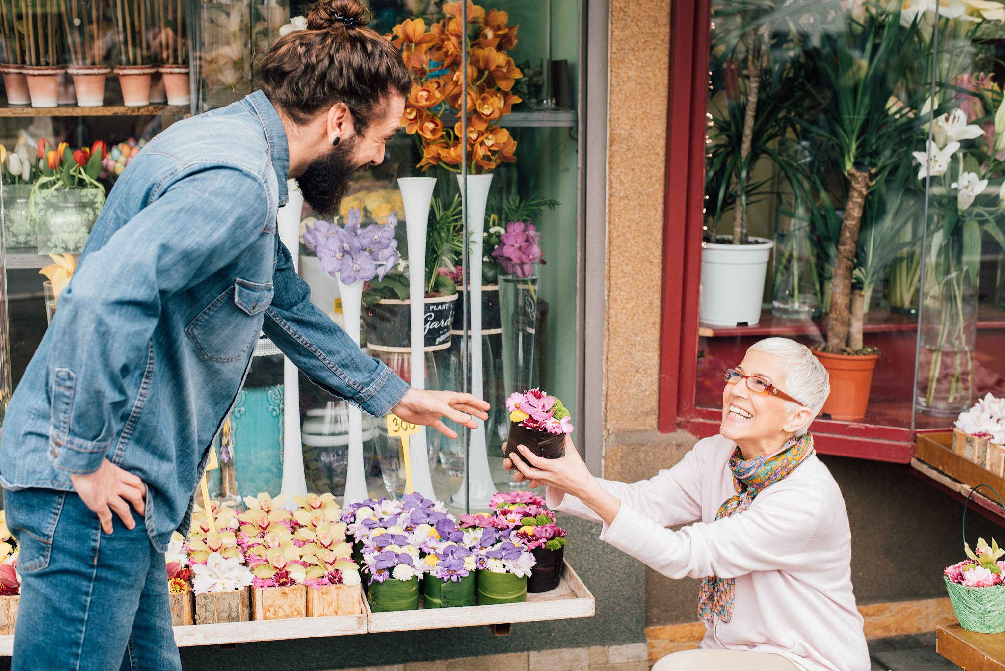 florist handing over a flower pot to a man