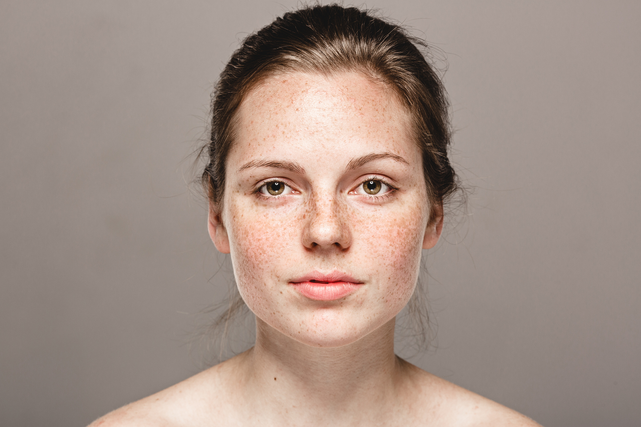young beautiful freckles woman face portrait with healthy skin