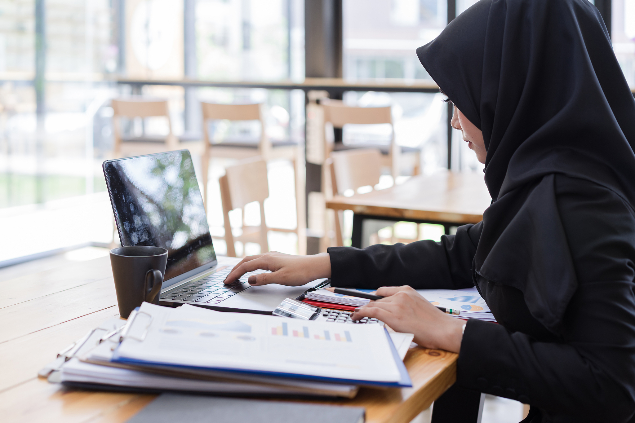 muslim business people wearing black hijab,working in coffee sho