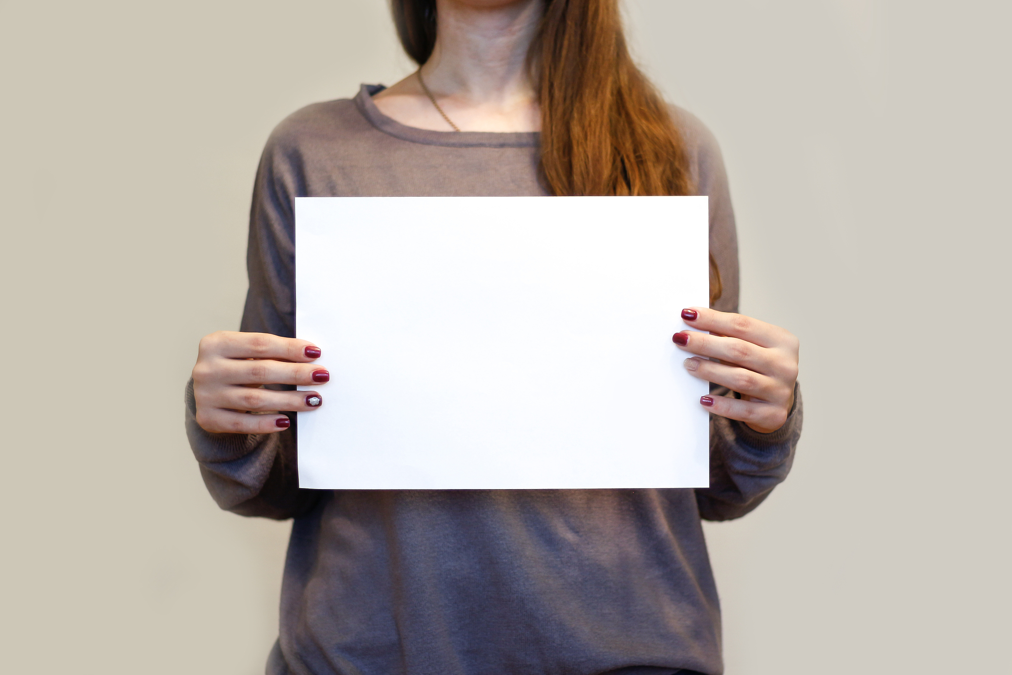 girl holding white a4 blank paper horizontally. leaflet presenta