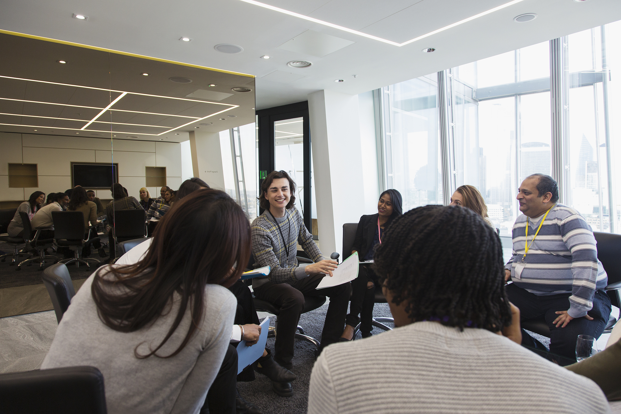 business people discussing paperwork in circle in meeting