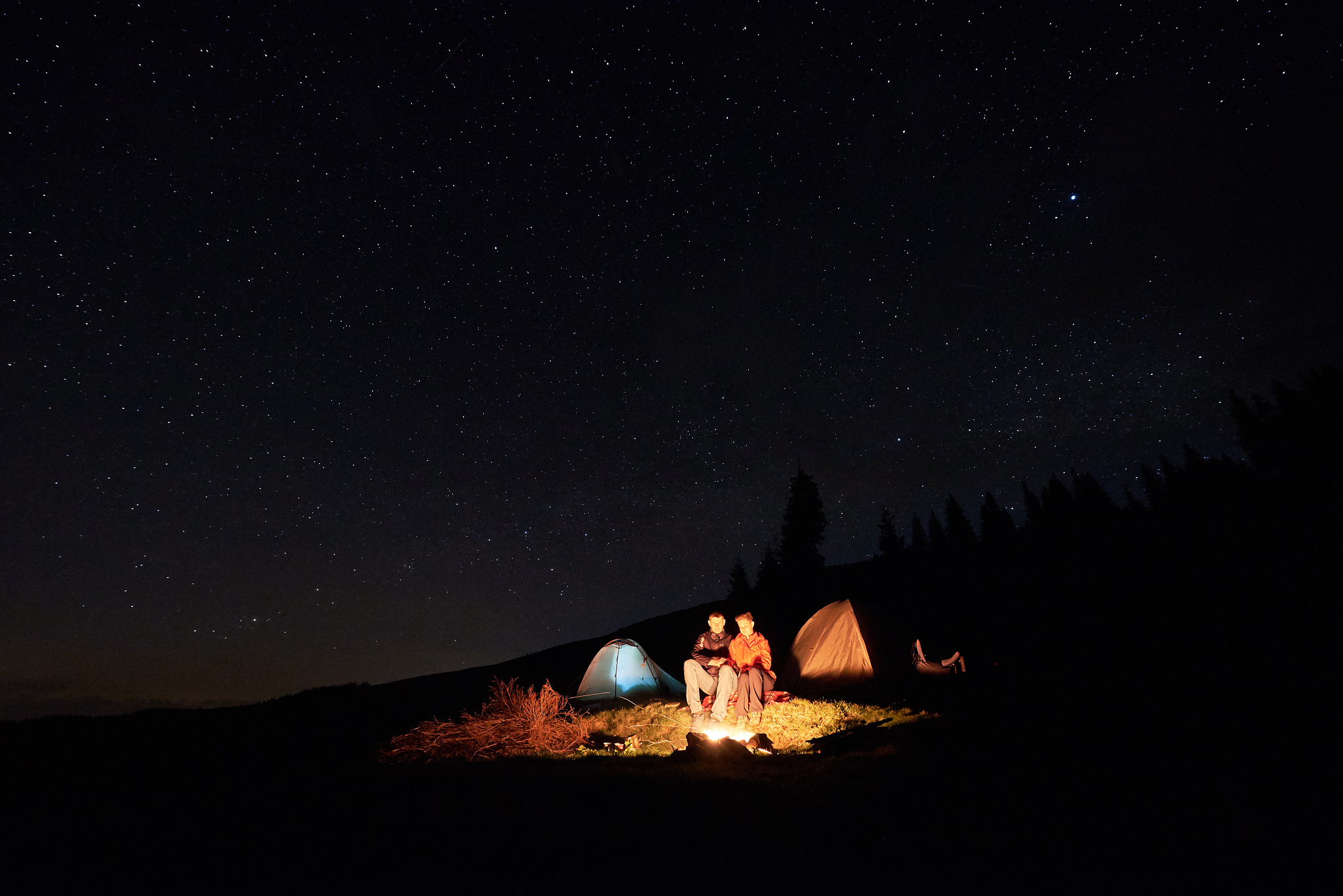 night camping in the mountains. couple tourists have a rest at a