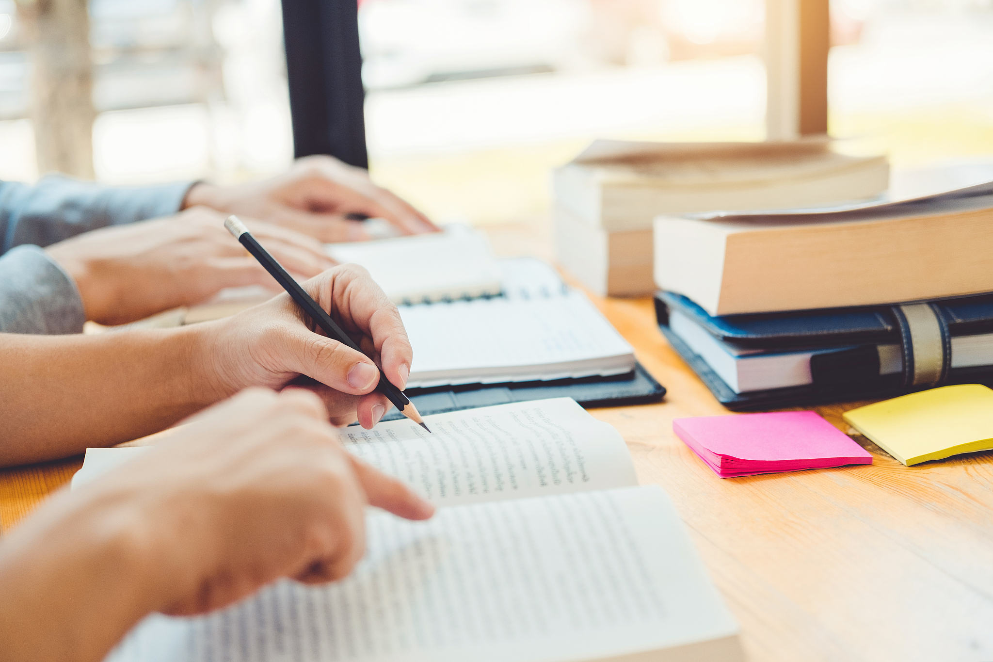 high school or college students studying and reading together in