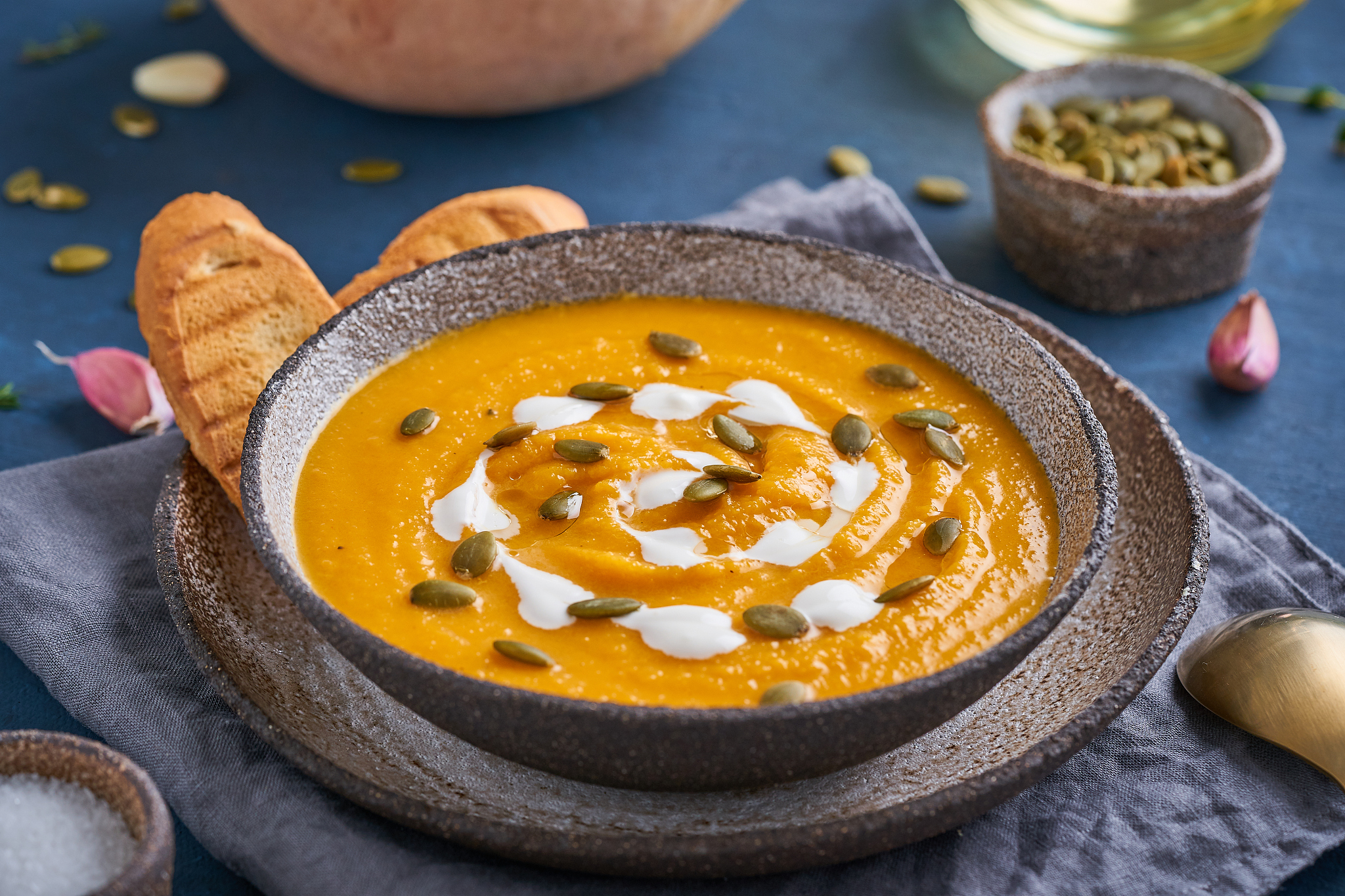 pupmkin cream soup puree on dark blue wooden table, dietary vege