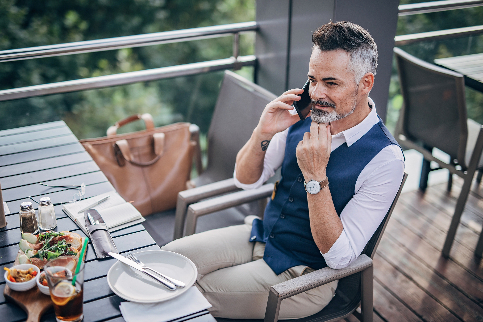 modern gentleman talking n mobile outdoors in restaurant
