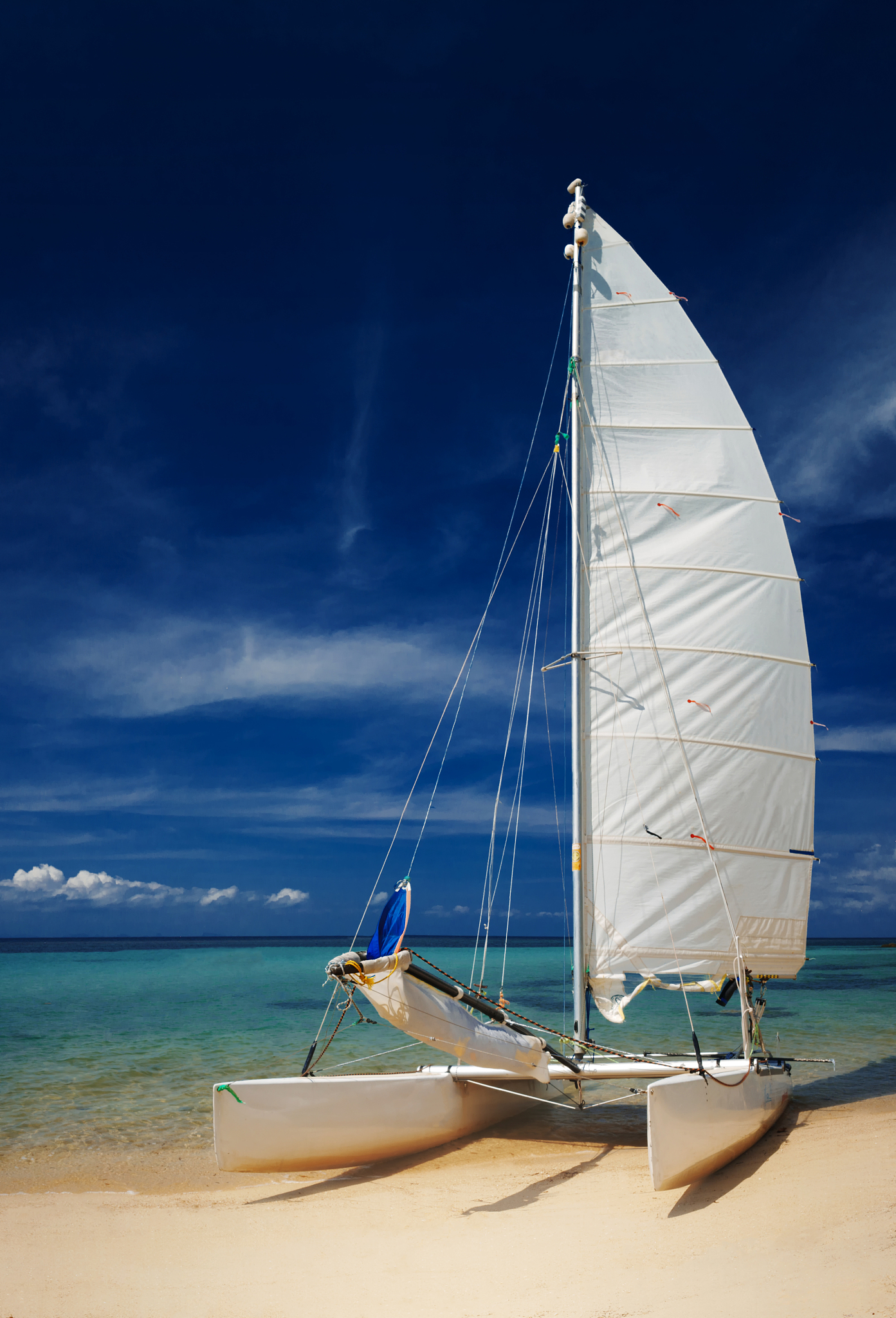 sail boat, catamaran, on tropical beach with blue water