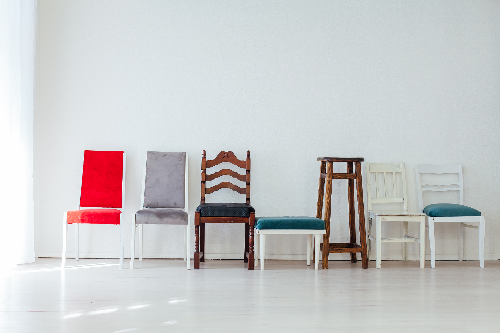 many multicolored chairs stand in the white room