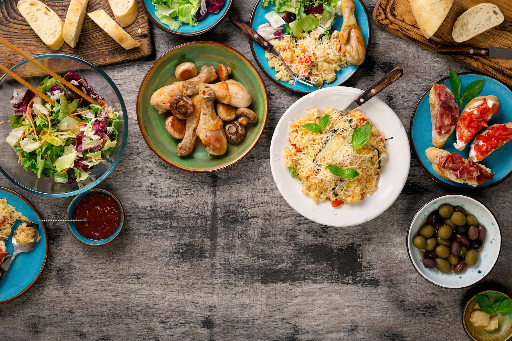 risotto, roasted chicken legs and snacks on a wooden table