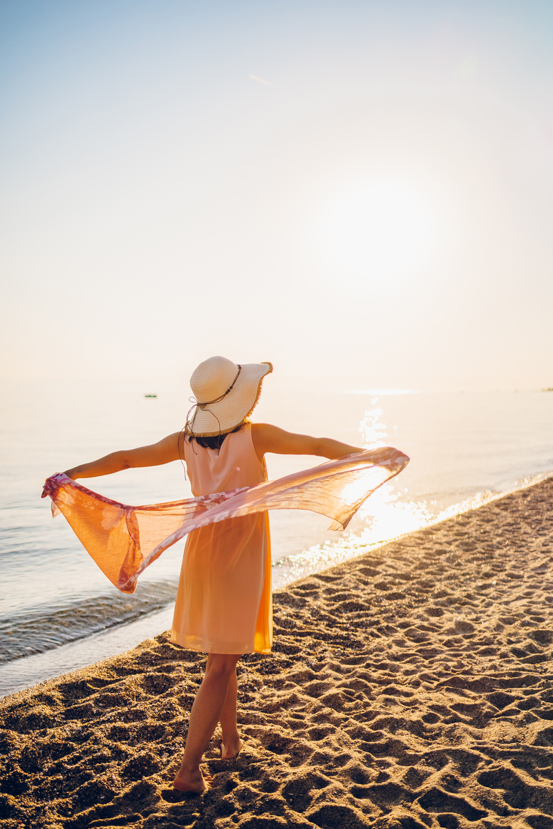 一个赤着上身的女人在海边拾贝壳