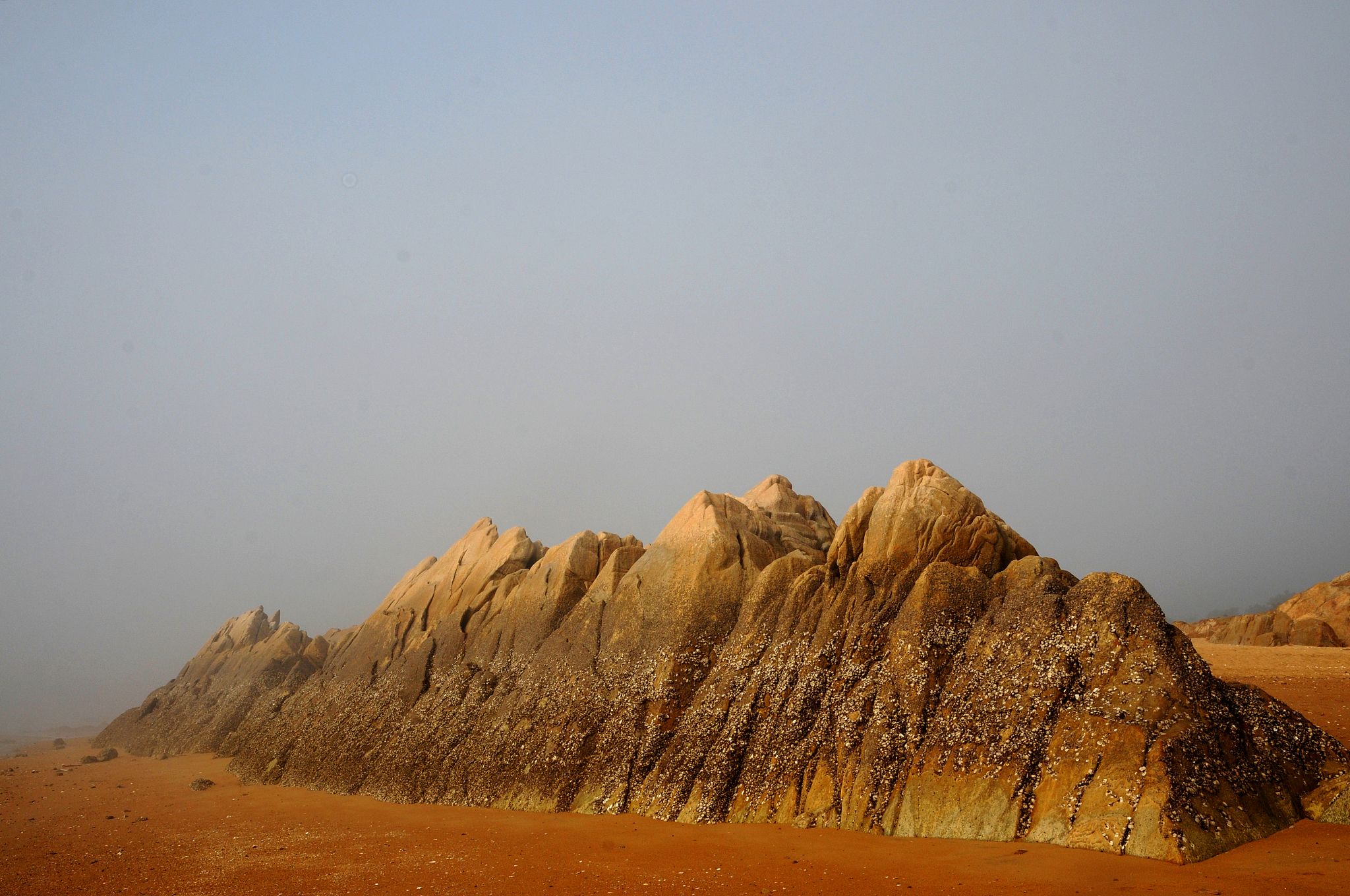 the rocks on the beach look like mini peaks