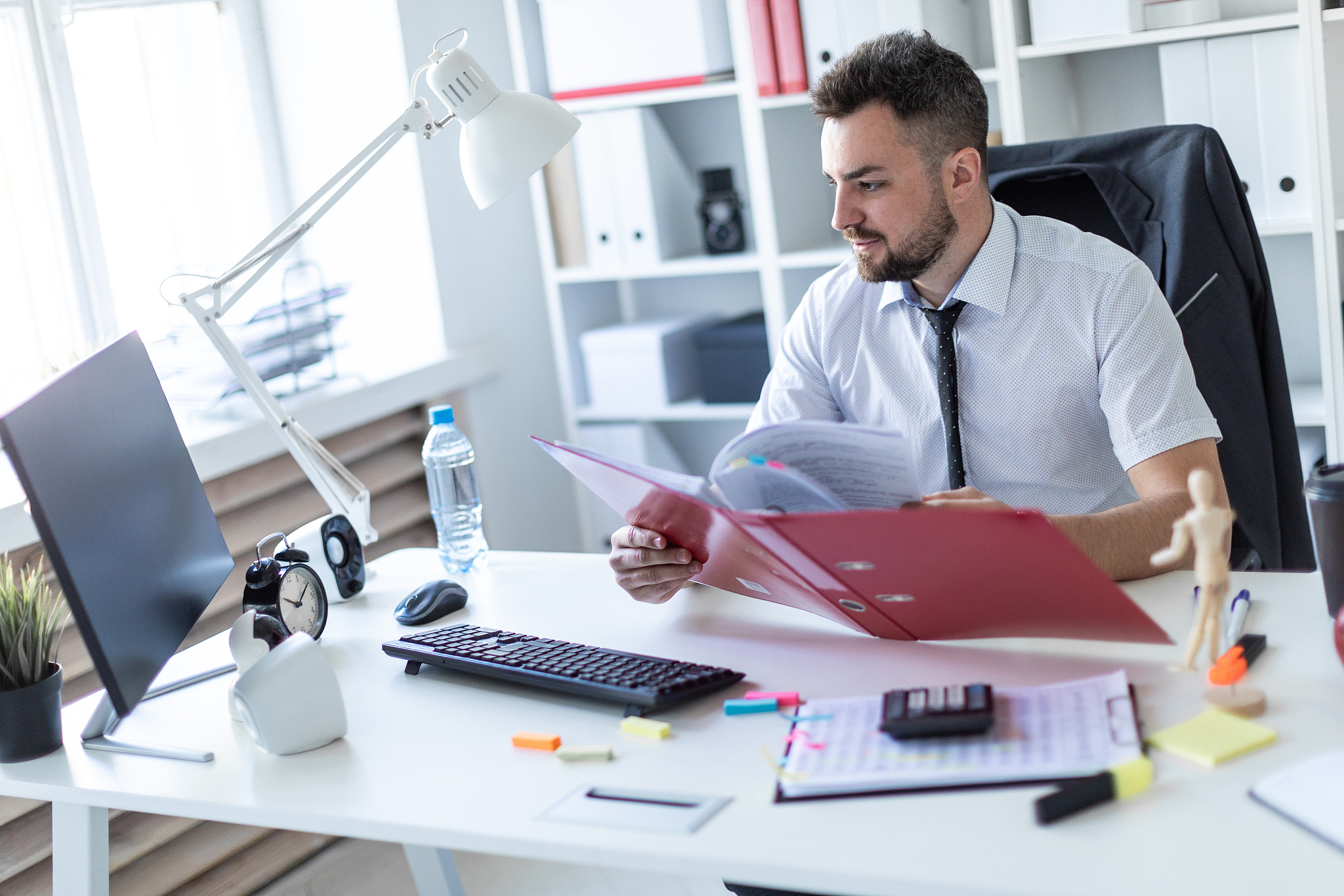 a man is sitting at a table in the office, working with document