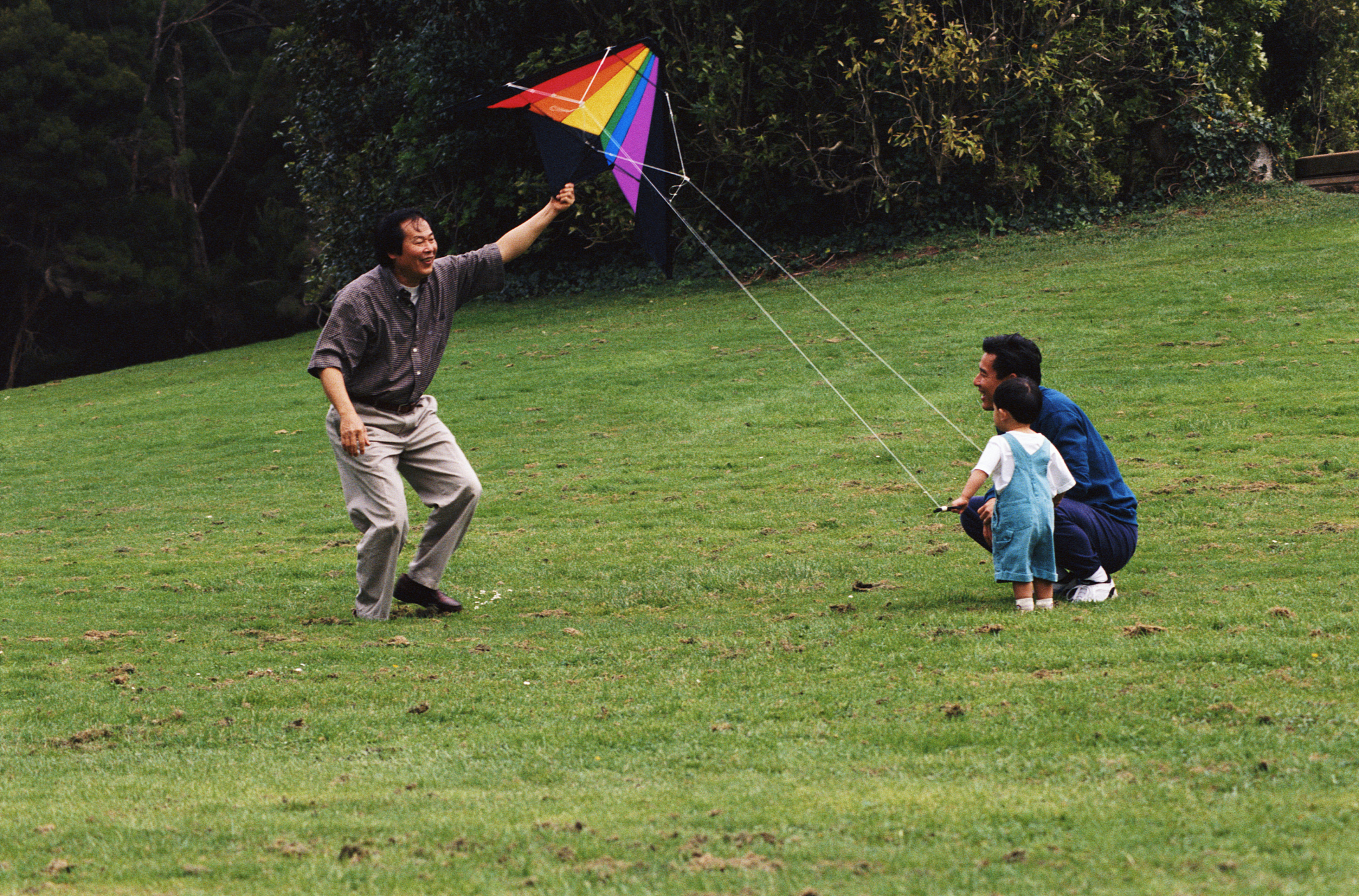 grandfather, father and son with kite