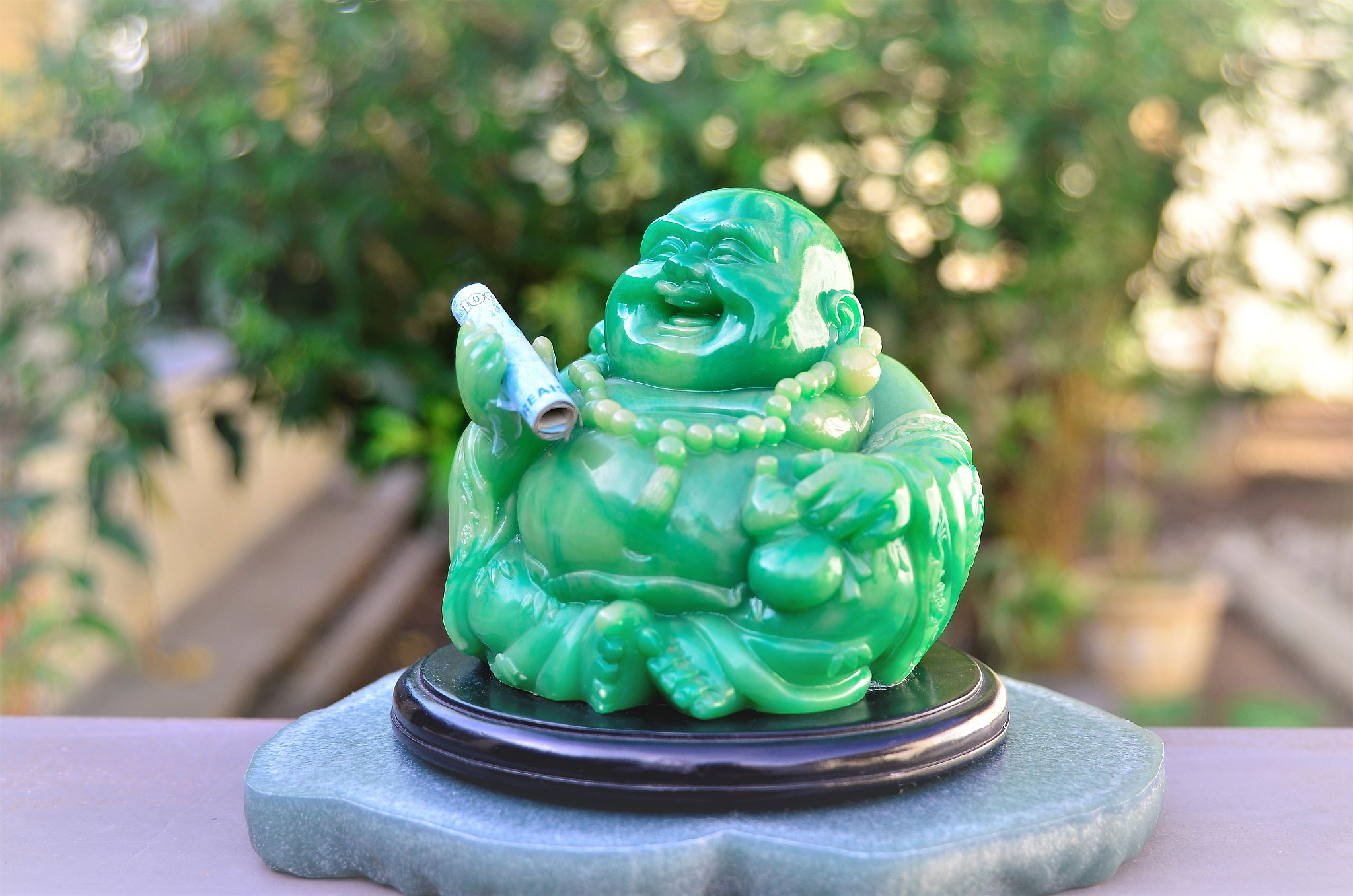 friendly green buddha holding money