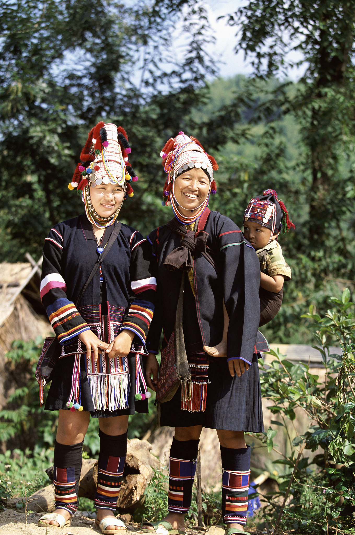 two akha women standing with a baby in chiang rai, thailand