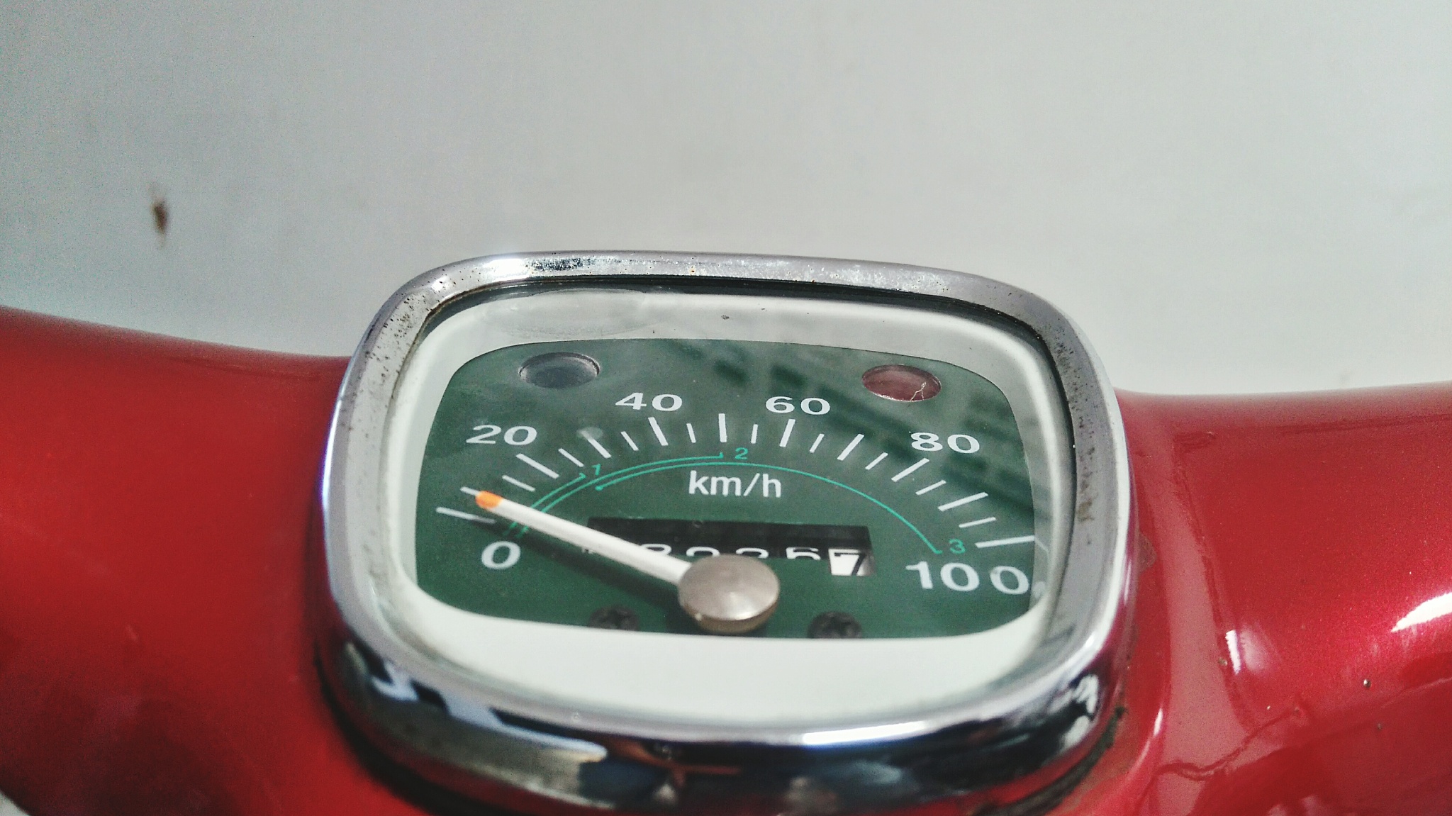 close-up of speedometer on red motor scooter