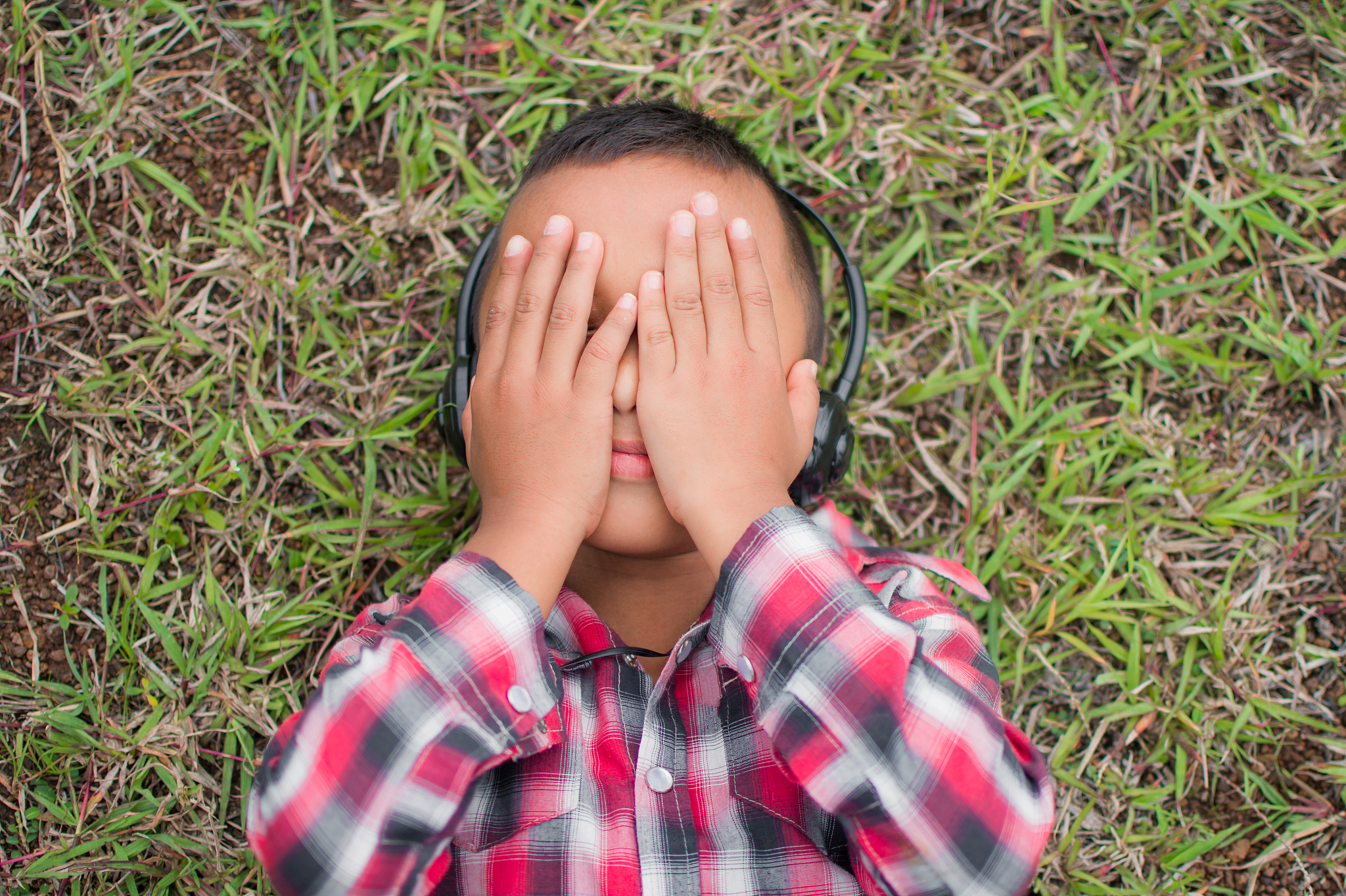directly above shot of boy lying on park