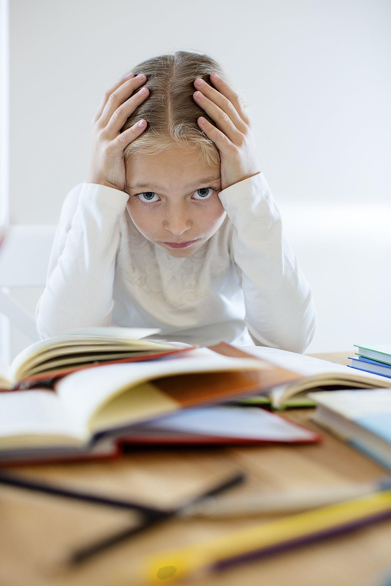 girl holding her head while studying