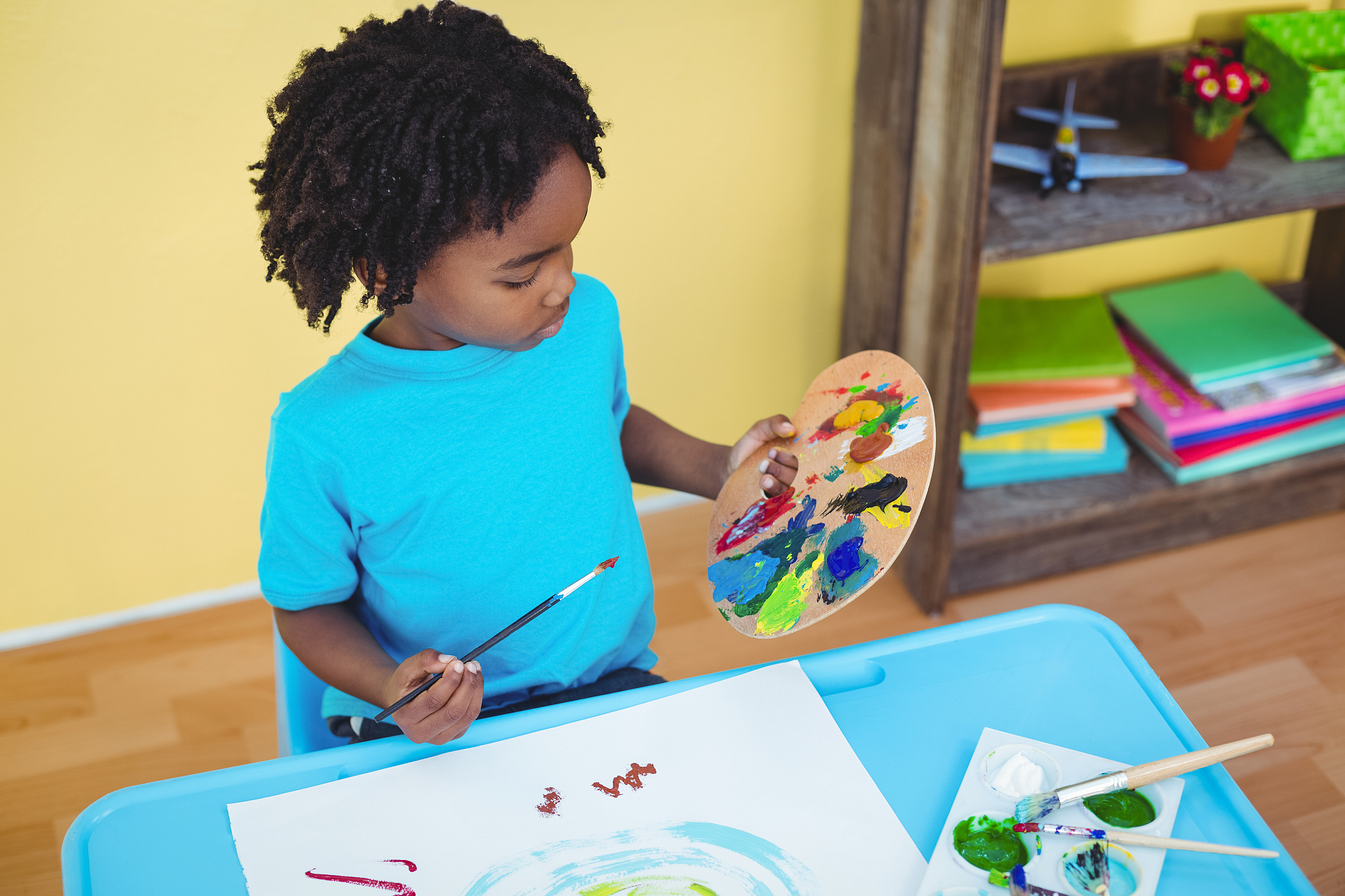 child using paints to make a pic