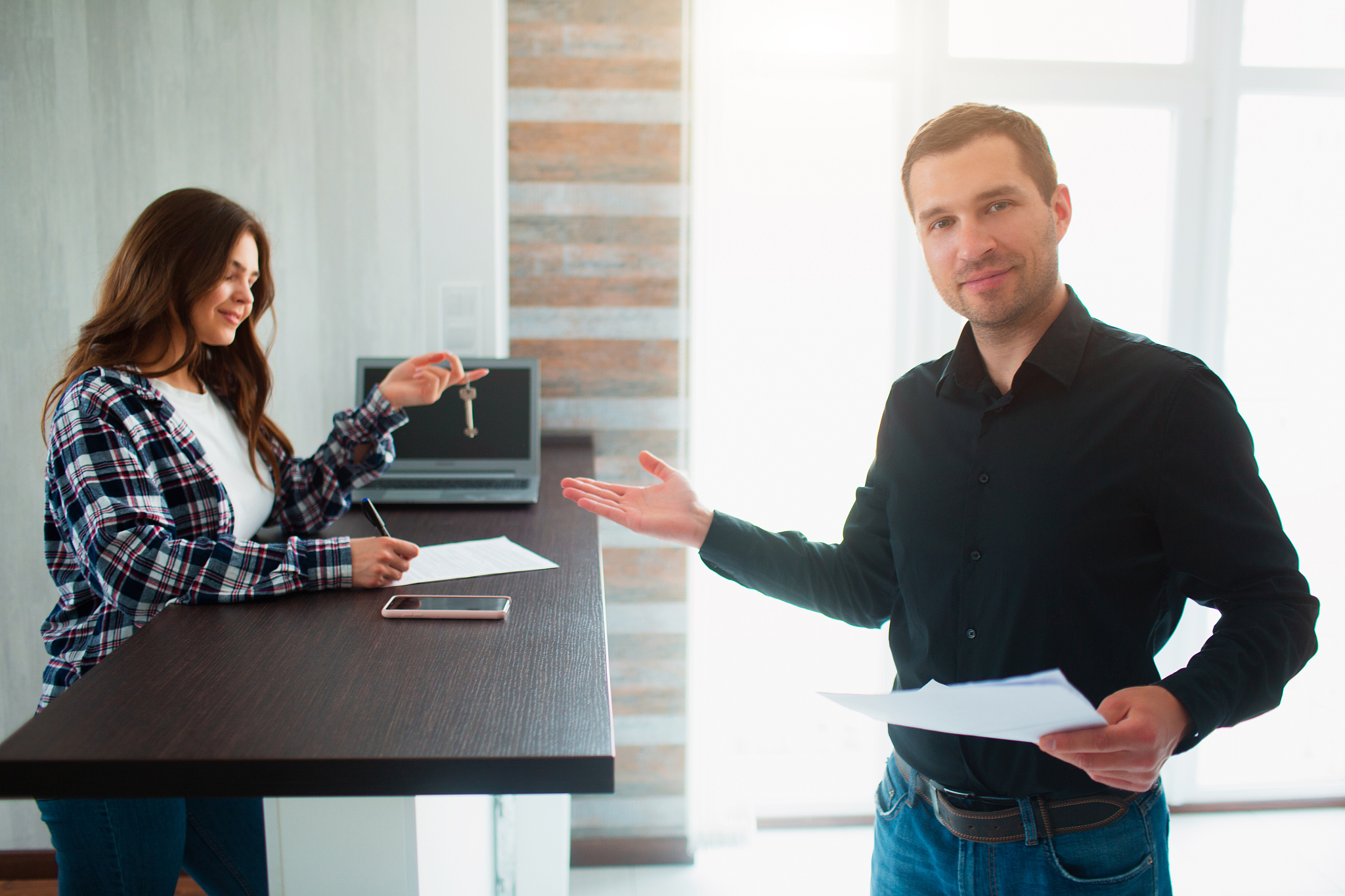 realtor, broker or landlord shows an apartment to a young woman.