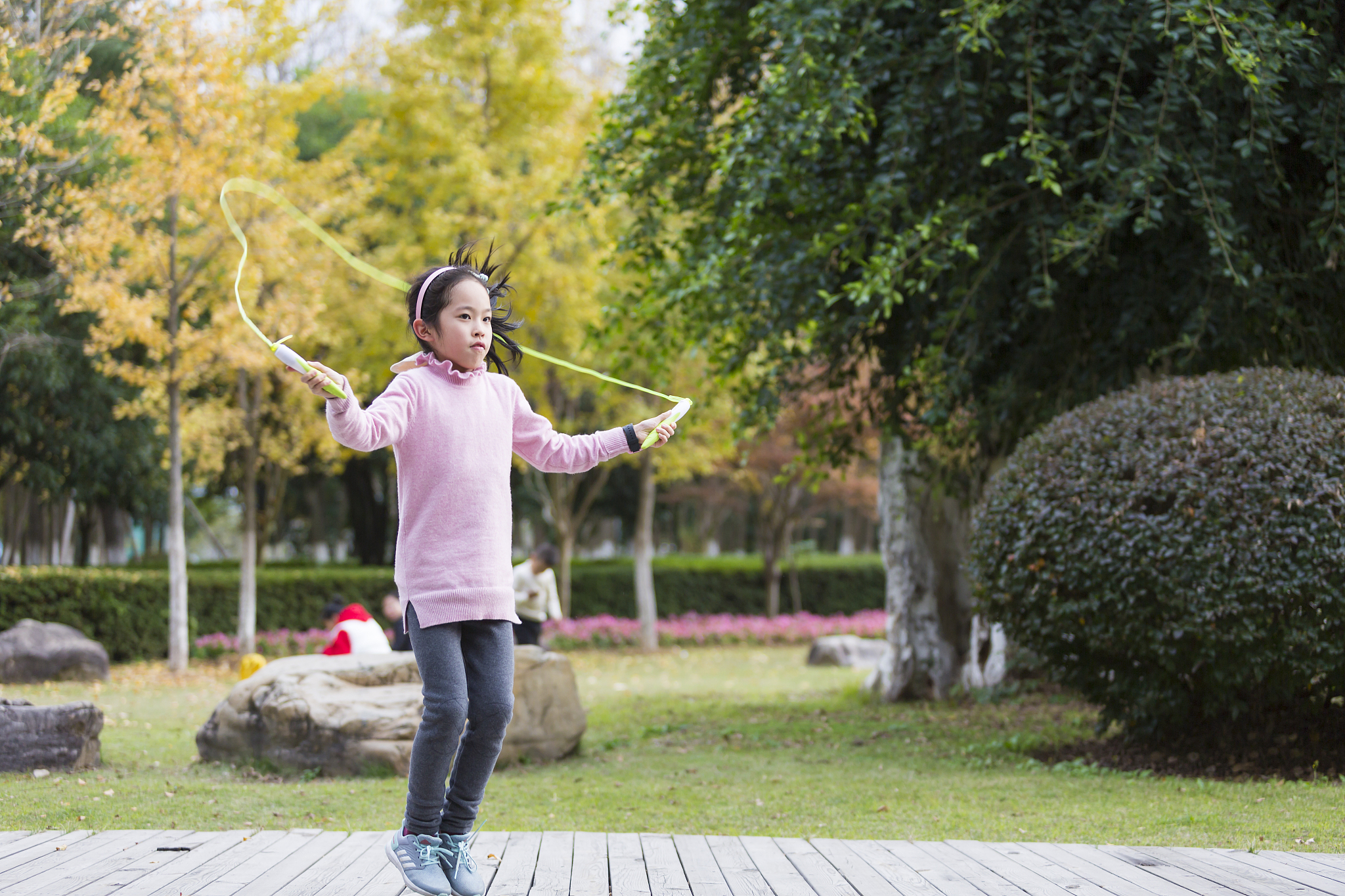 girl jumping rope in garden.