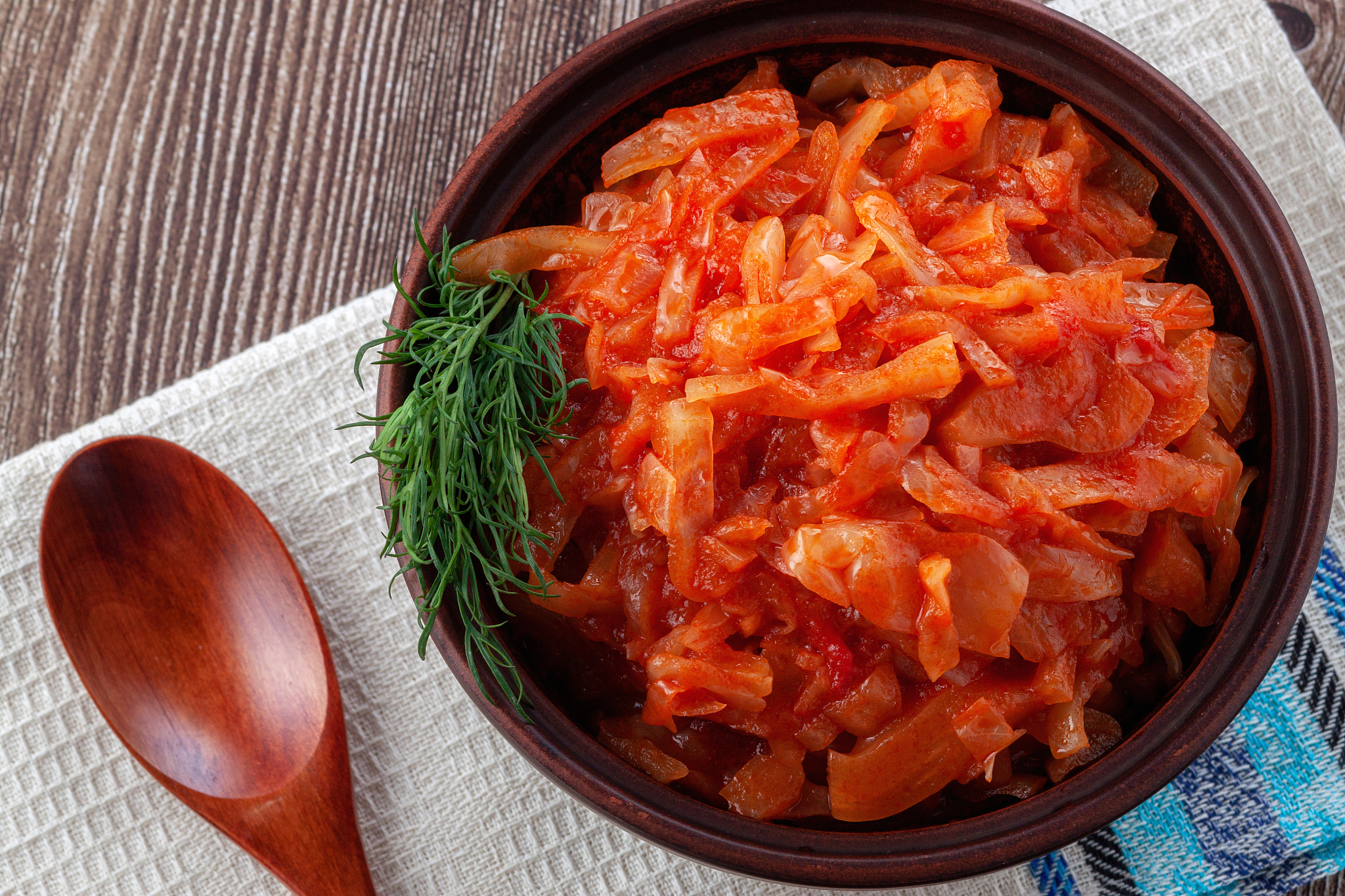 braised cabbage with tomatoes on an old wooden background in rus