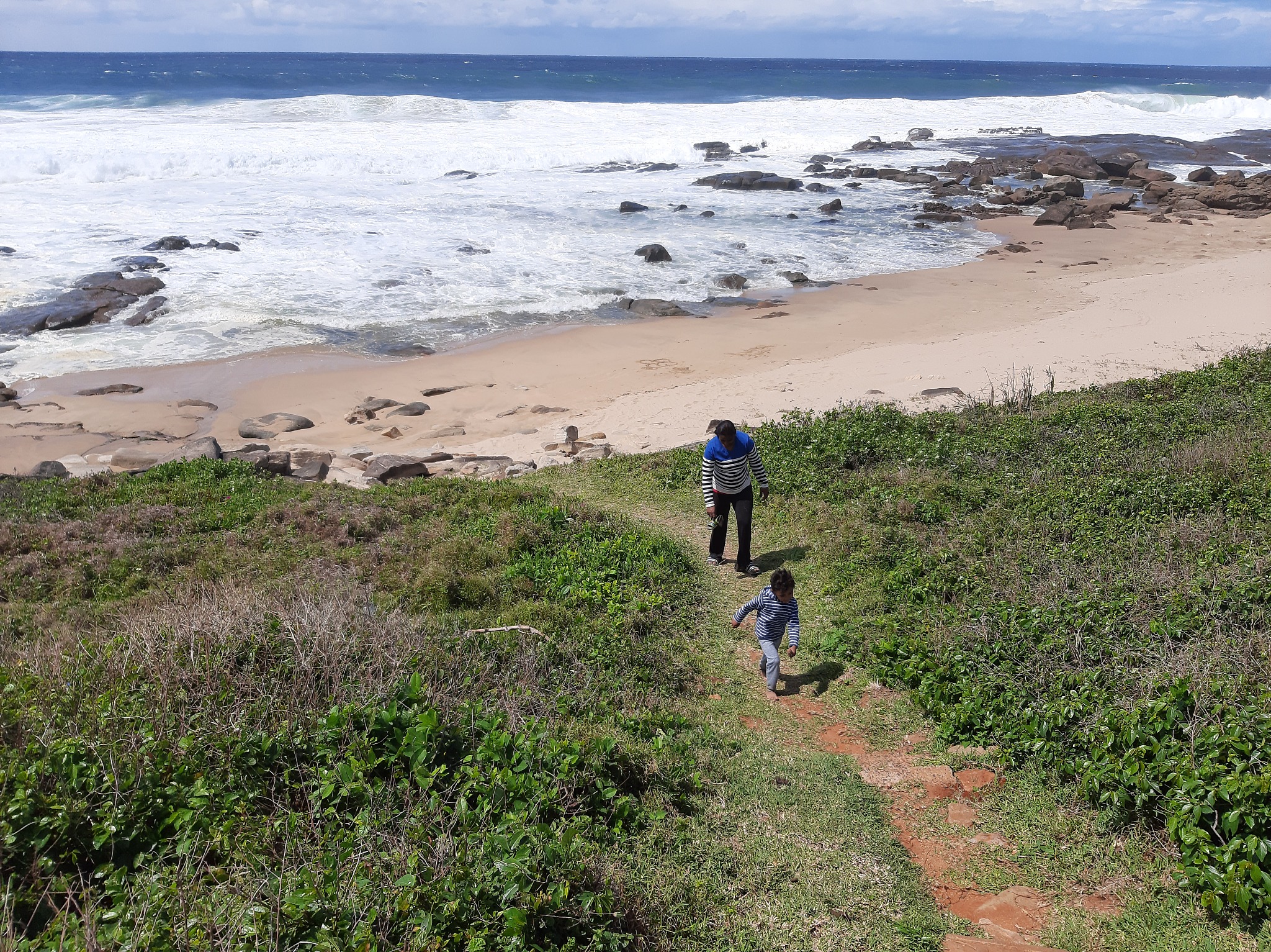 rear view of men walking on beach