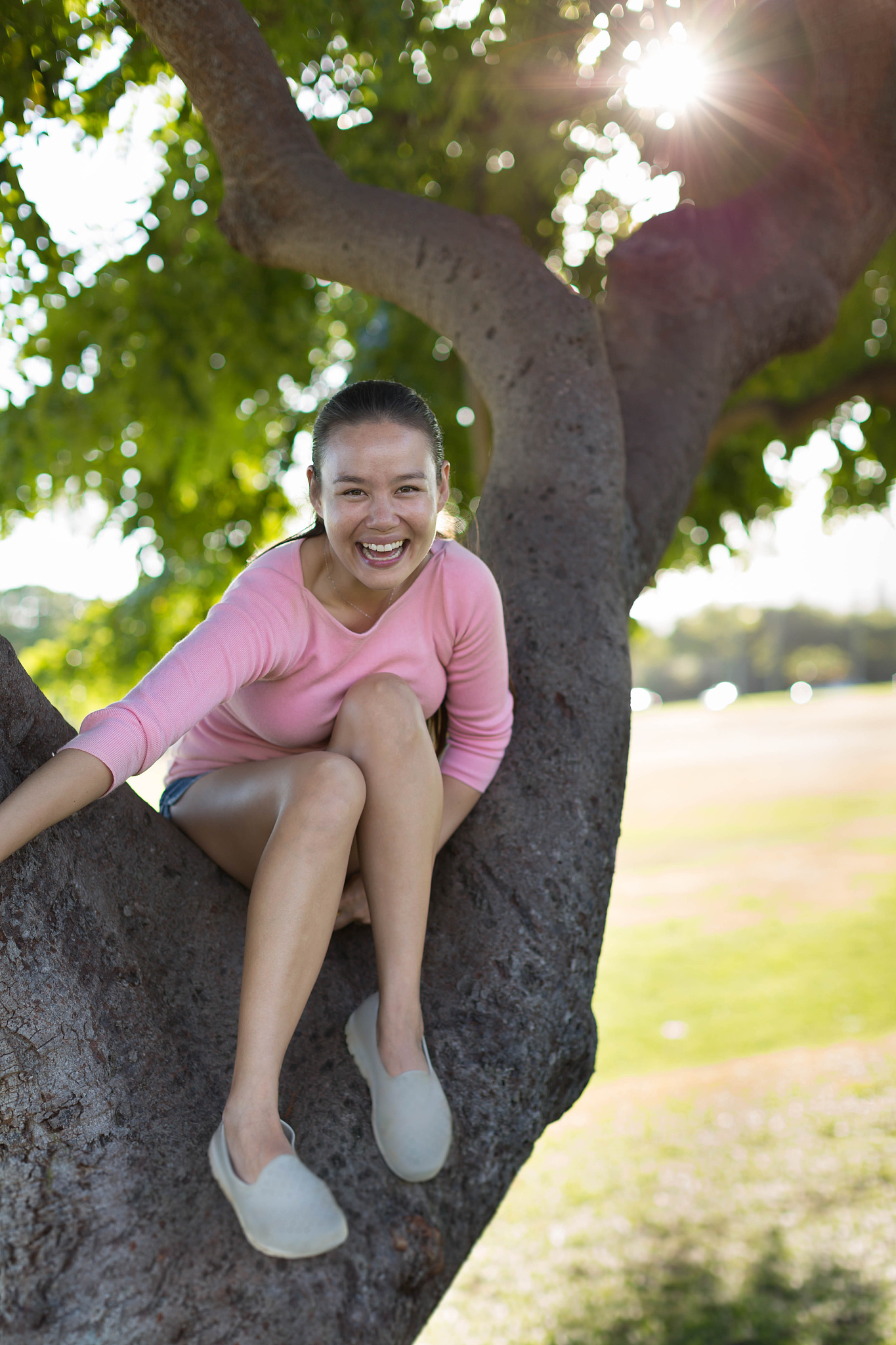 young caucasian/asian woman smiling and happy, having fun sittin