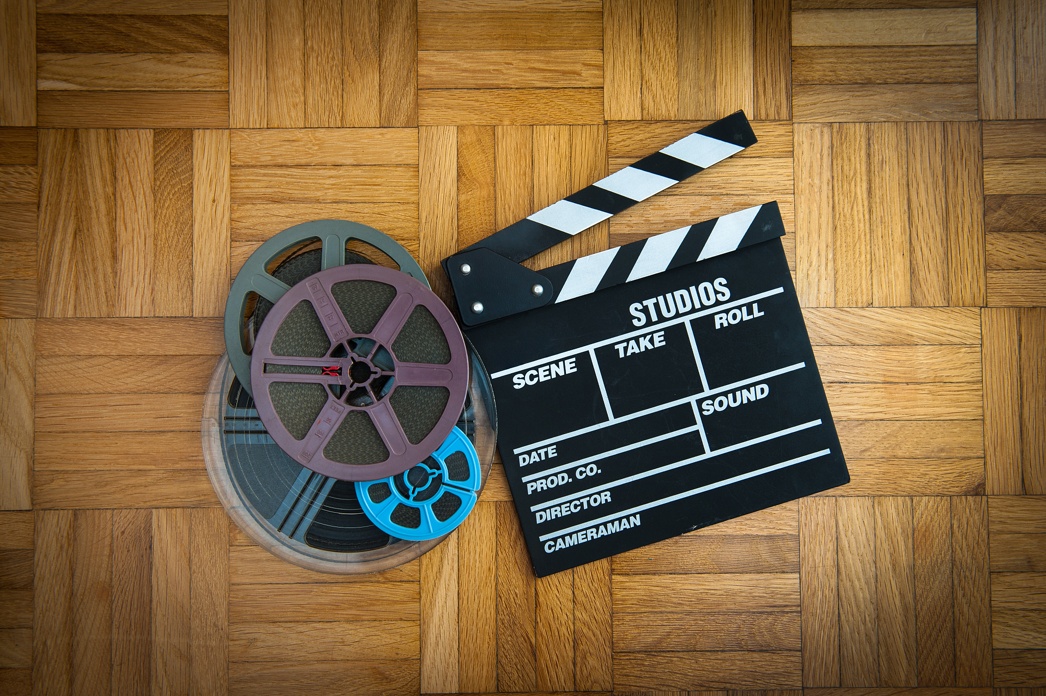 movie clapper board and film reel on wooden floor