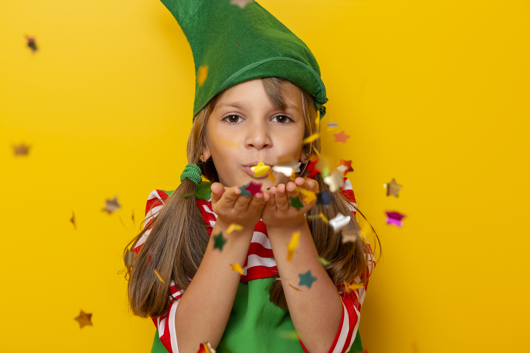 christmas elf blowing confetti
