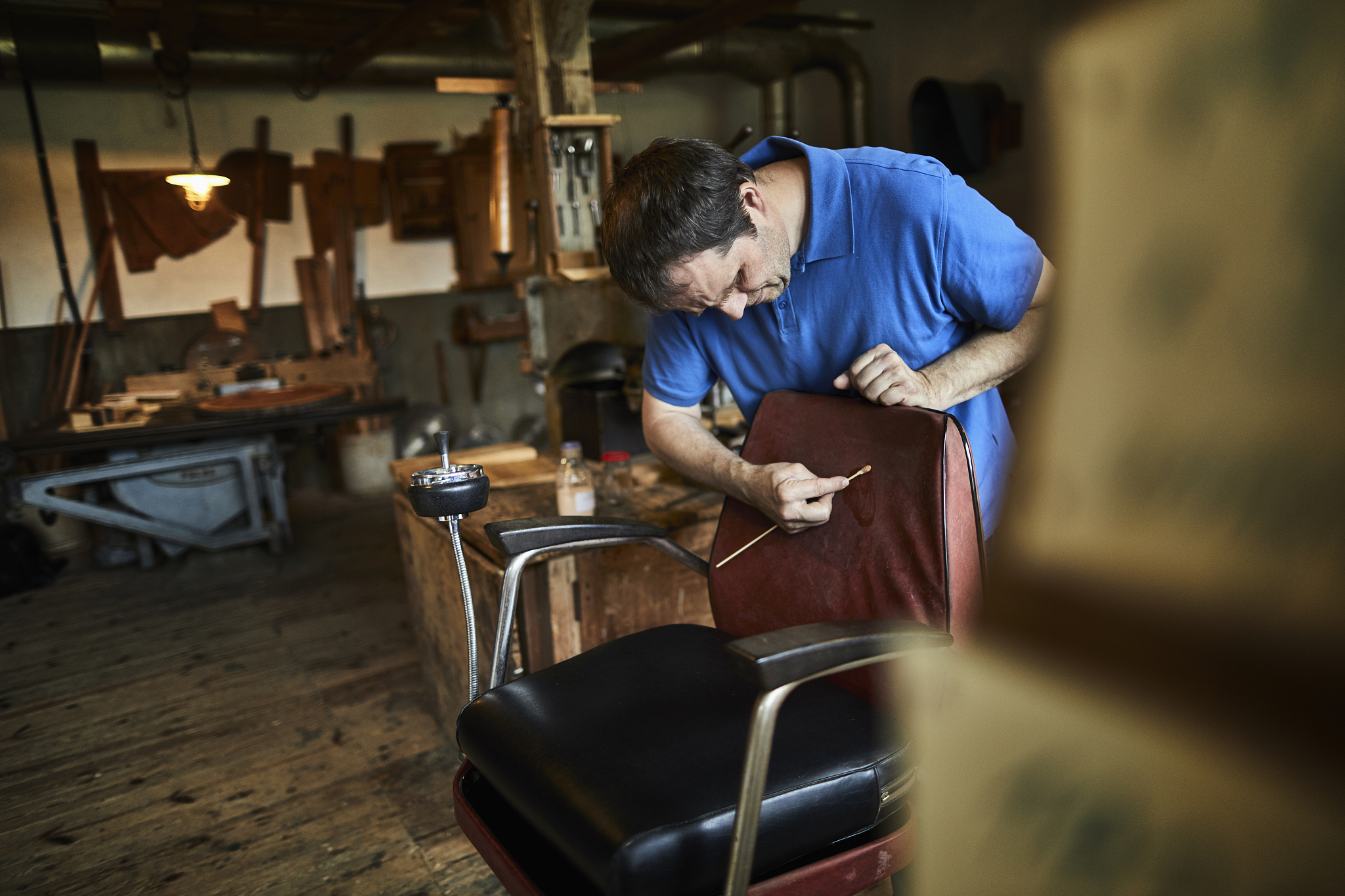 furniture restorer working on chair in his workshop