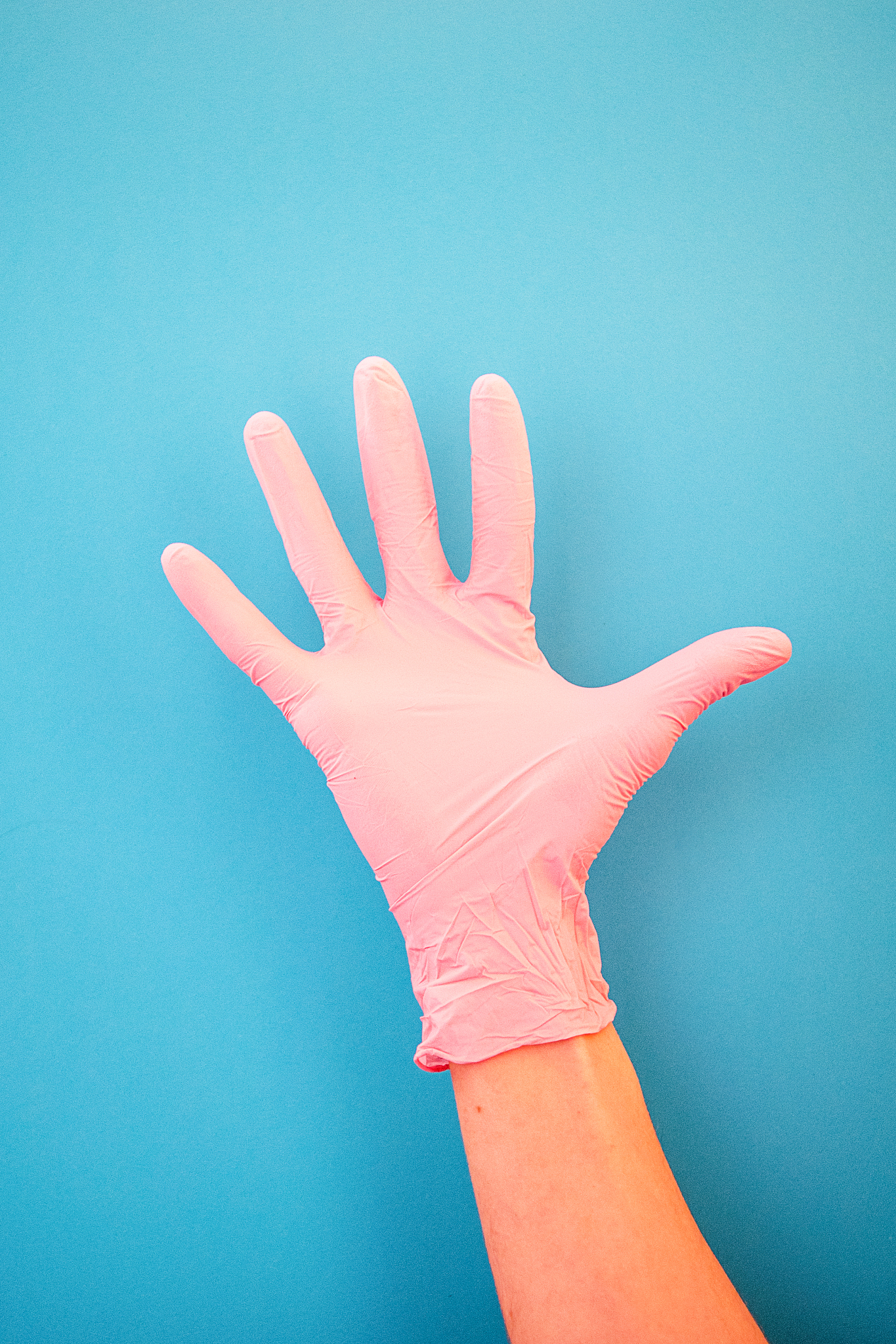 pointing a finger at number five, wearing pink medical gloves, a