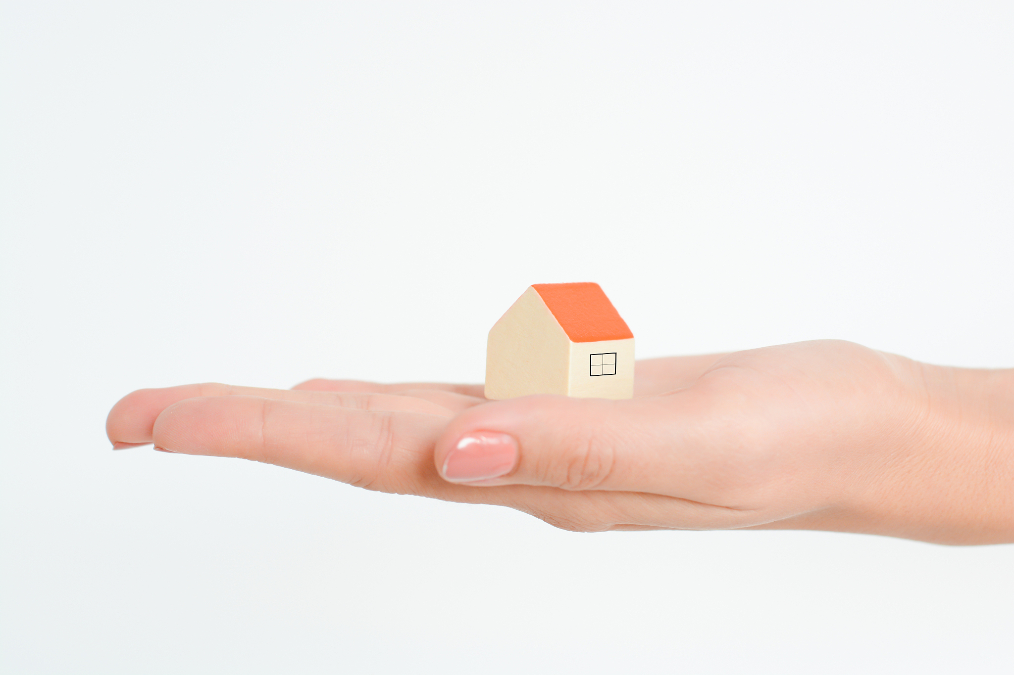 close-up of woman's hands holding a small model house