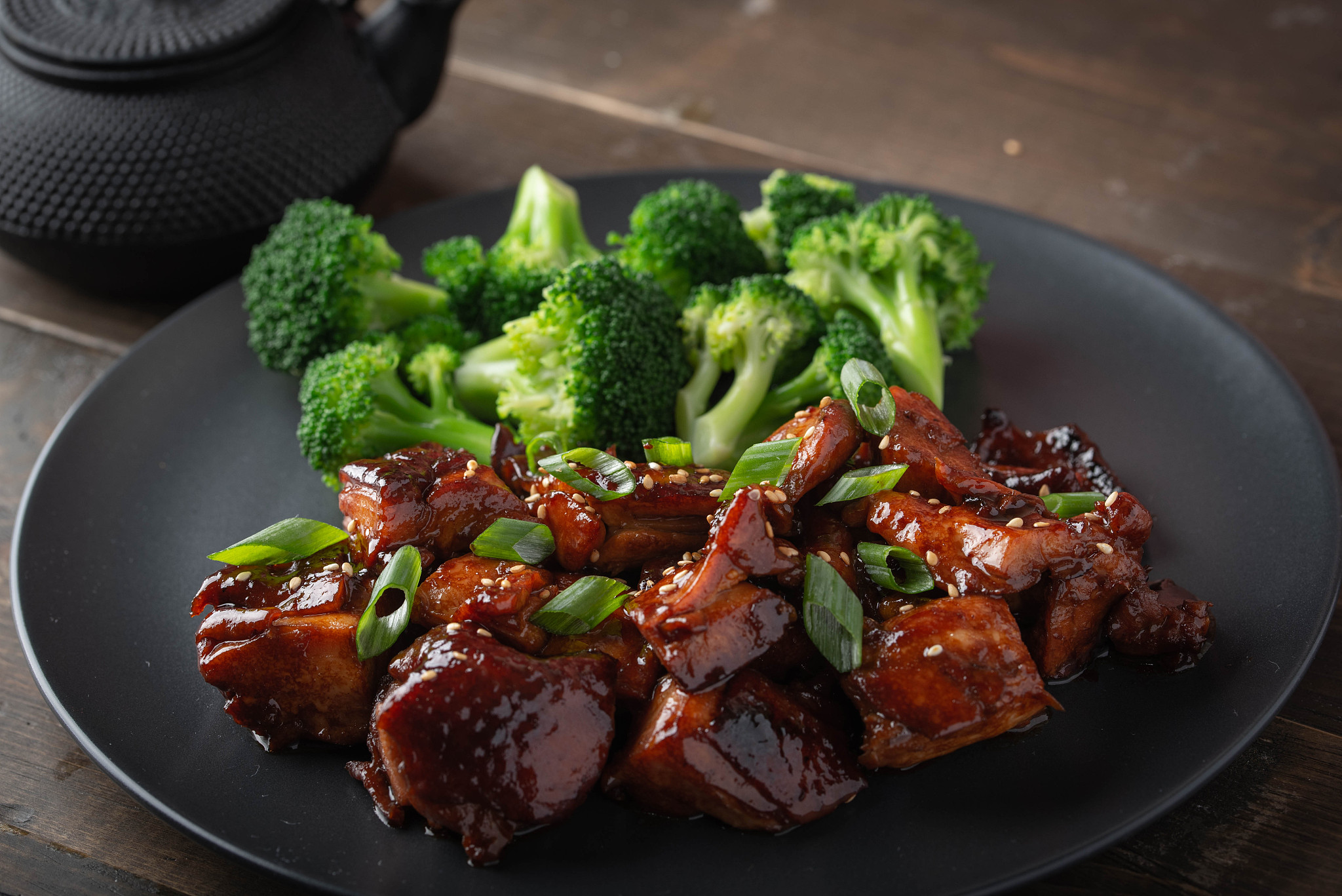 teriyaki chicken and broccoli on black plate