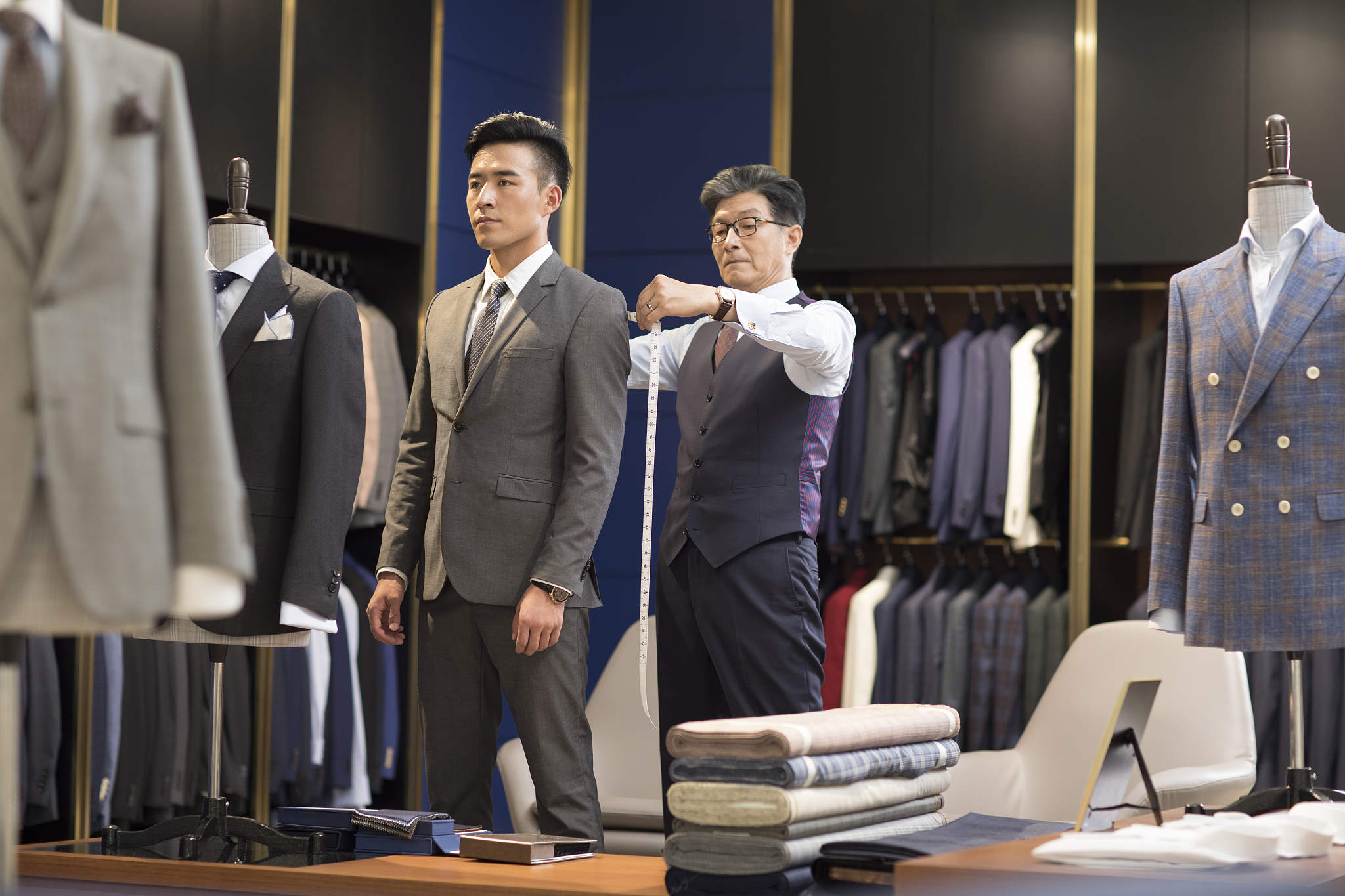 服装设计师为顾客量尺寸