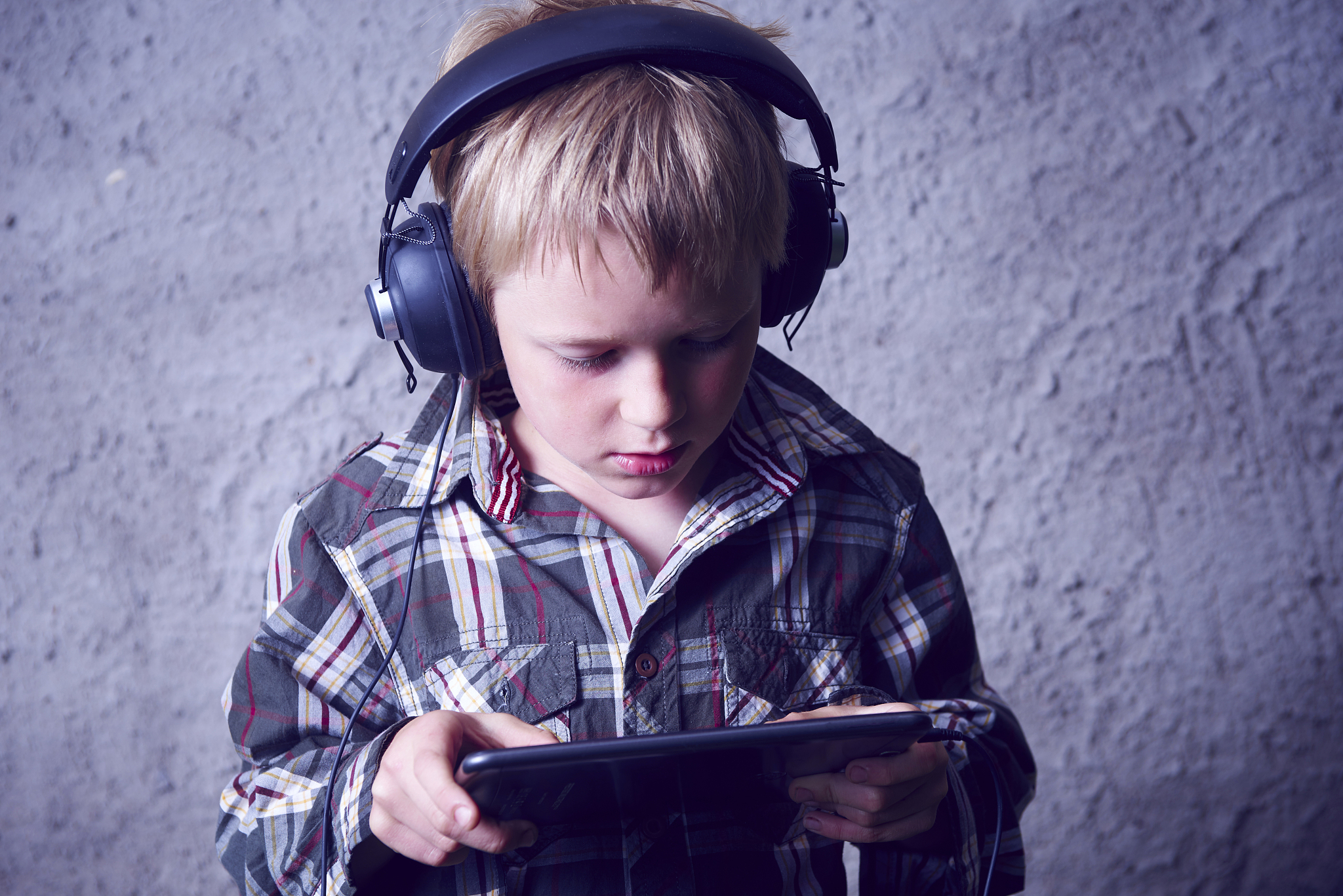 child boy listening to music, watching movie or playing games on