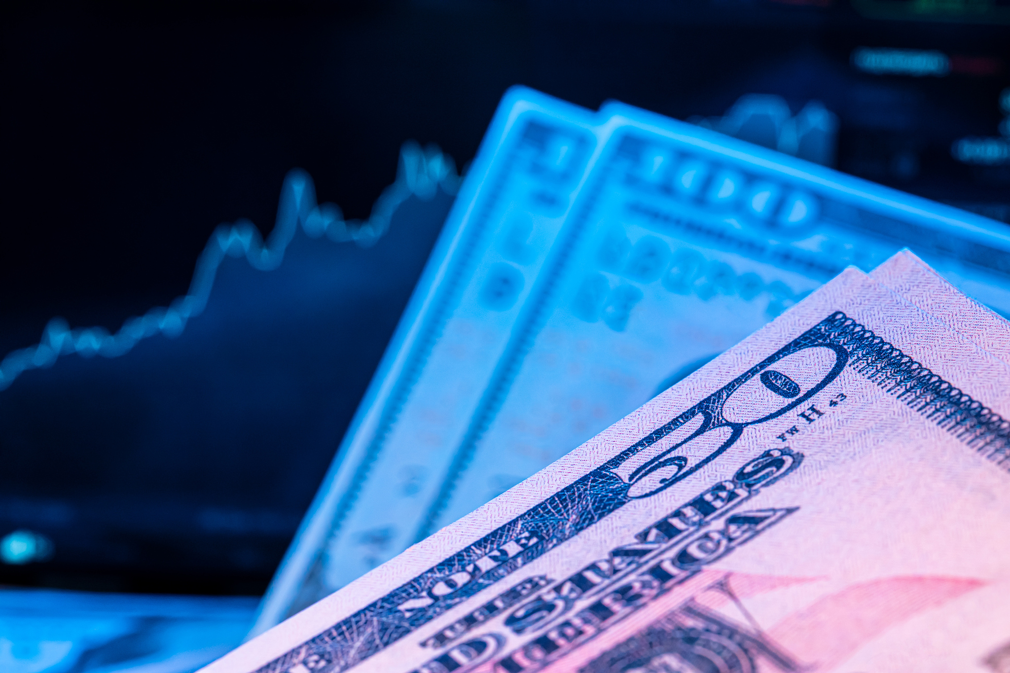 dollars in front of a monitor with a price chart. forex and trad
