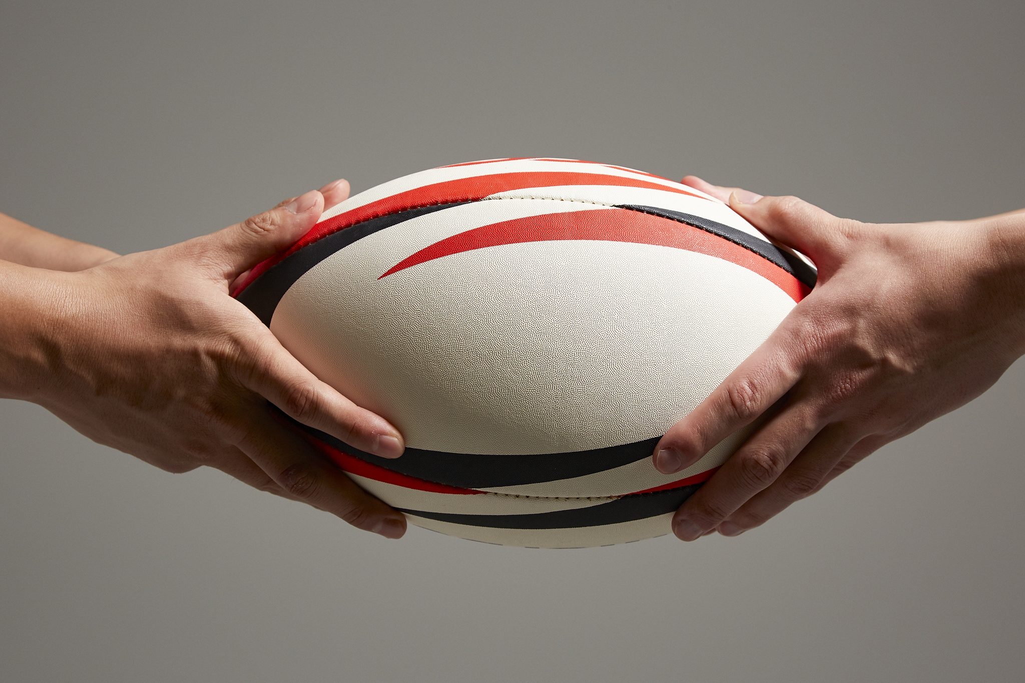 hands holding rugby ball