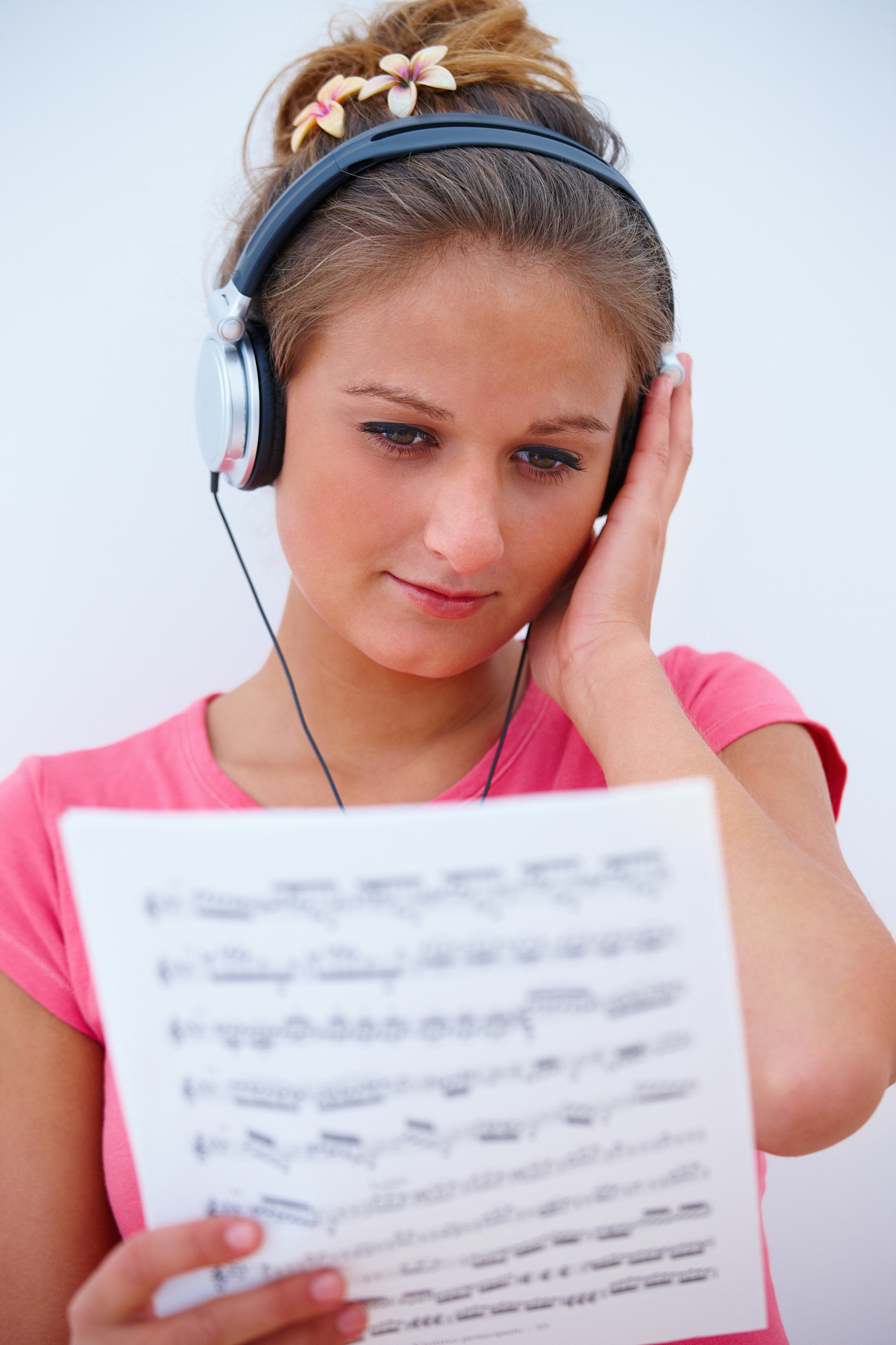 young female singer listening to music holding music sheet
