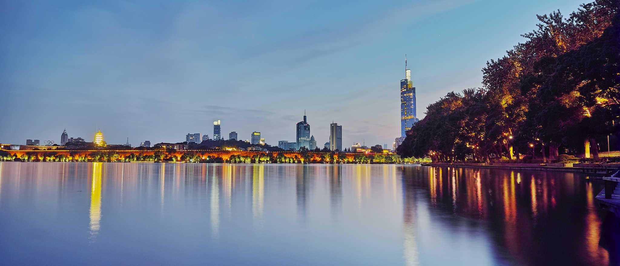 buildings in city by lake against sky