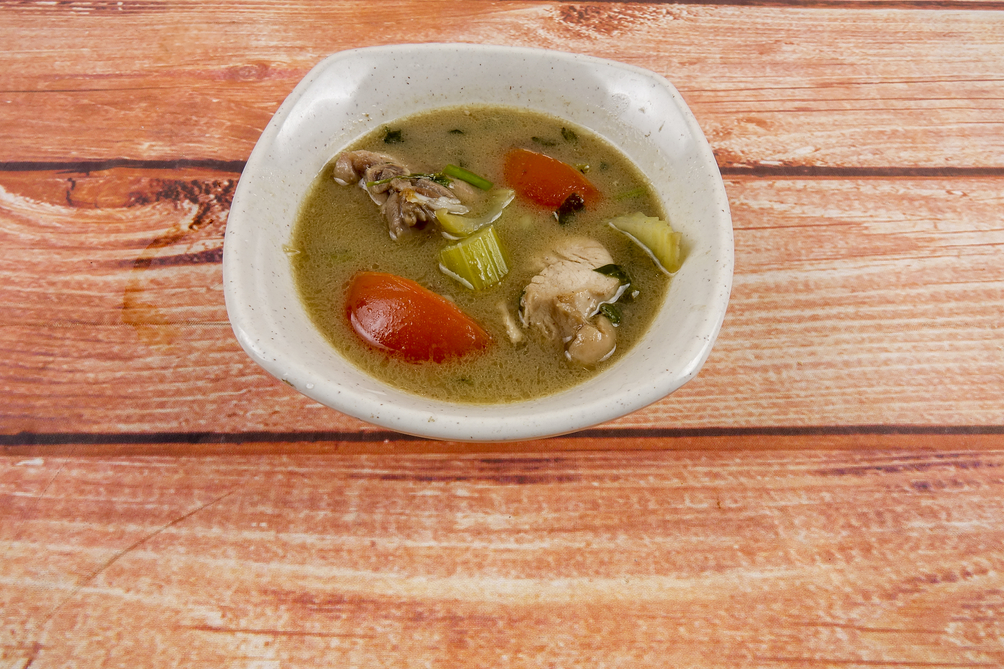 chicken soup on wooden table. top view.