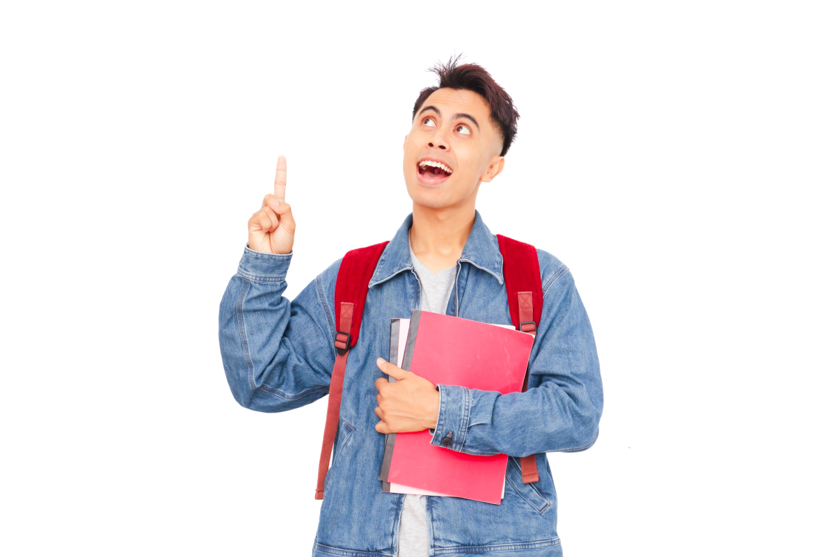一个兴奋的亚洲男性大学生,背着背包,拿着书,向上指向