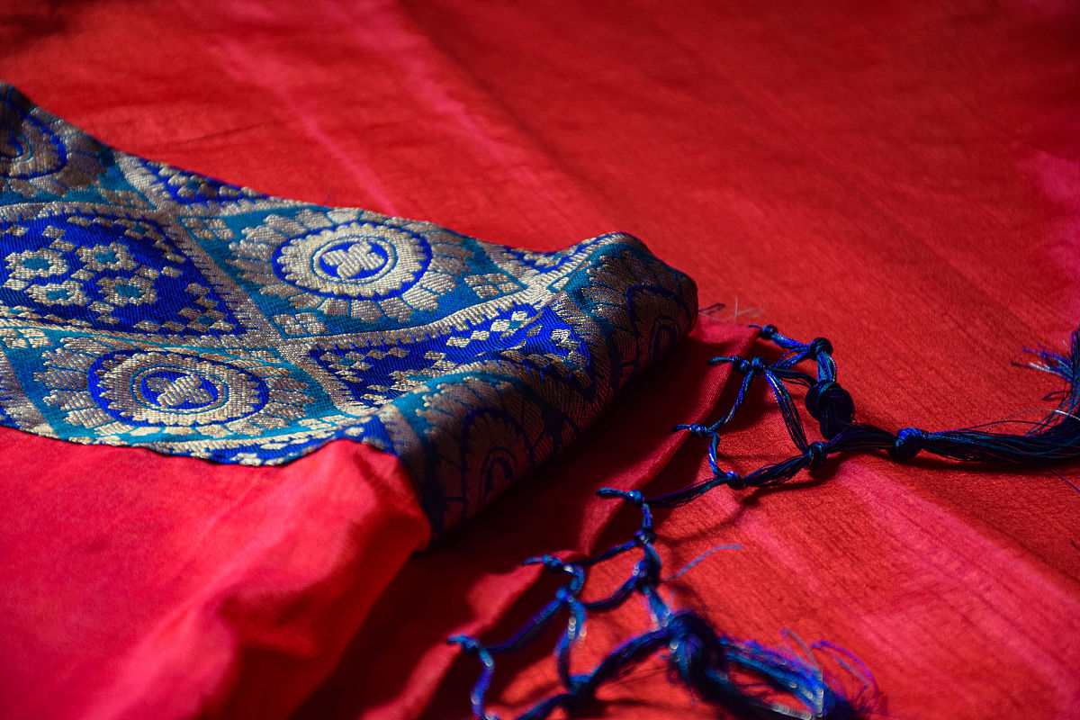 简单描述一下 一个红色衣服的女孩 戴着精美的头饰和项链头上还有一朵花 身边站着一个蓝色衣服戴着金色发冠的男孩子