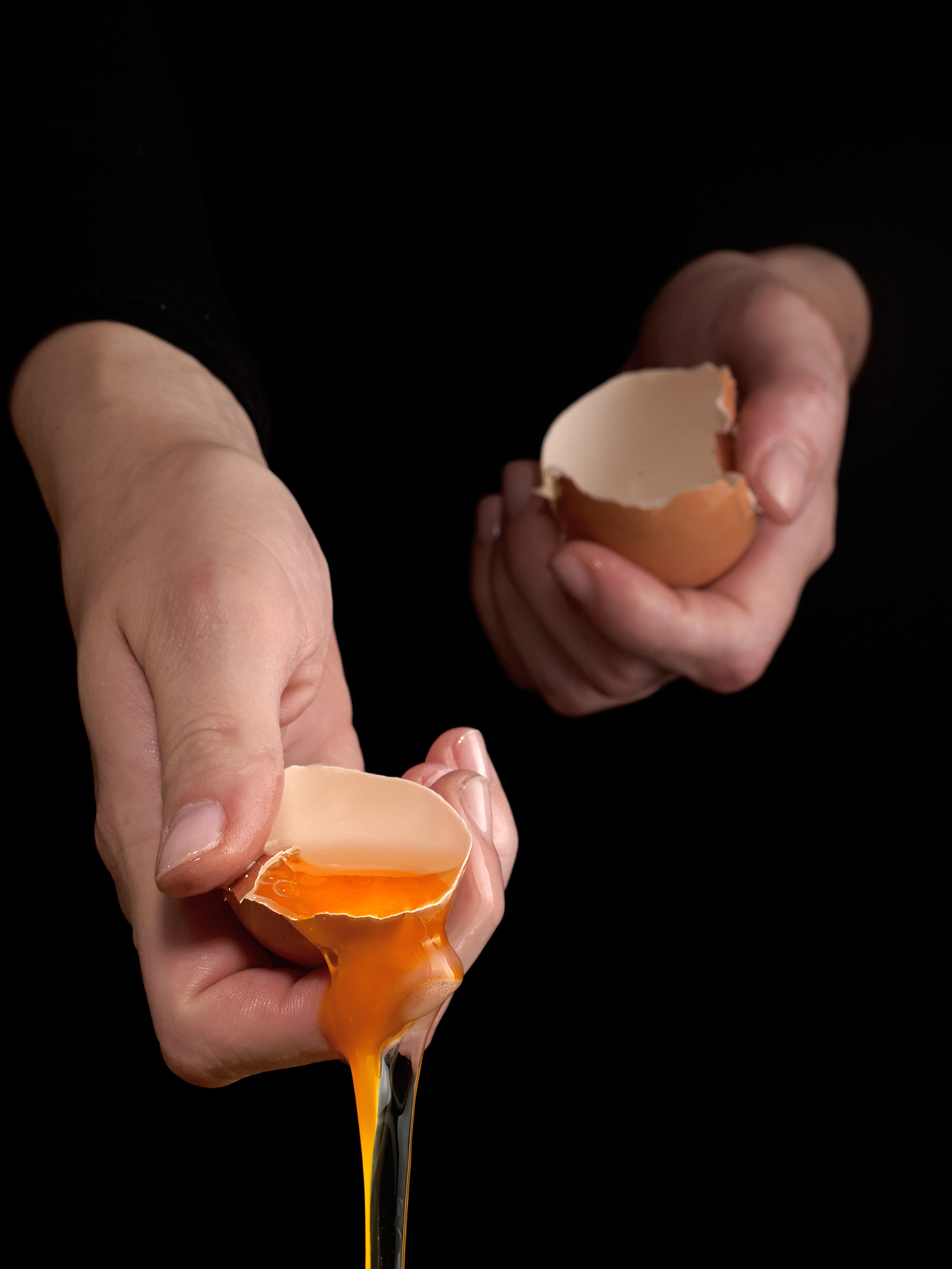 hands breaking an egg.