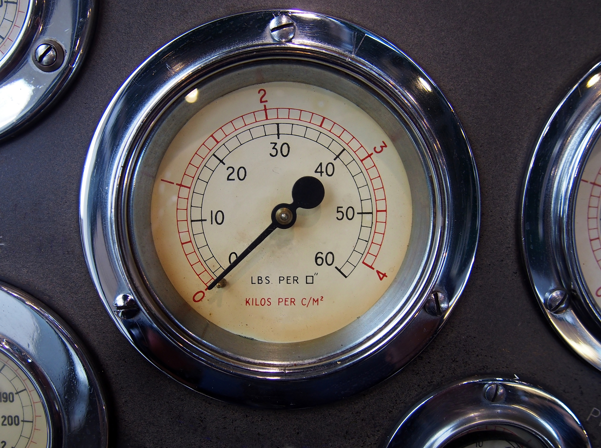 a round metal pressure gauge with a shiny chrome surround on a c