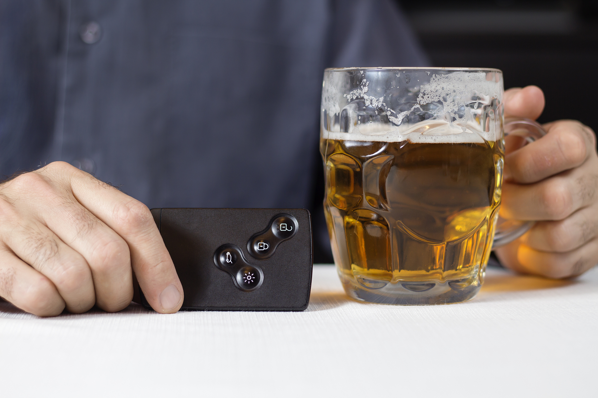 hands of the man in one hand hold the key card in the car, in th