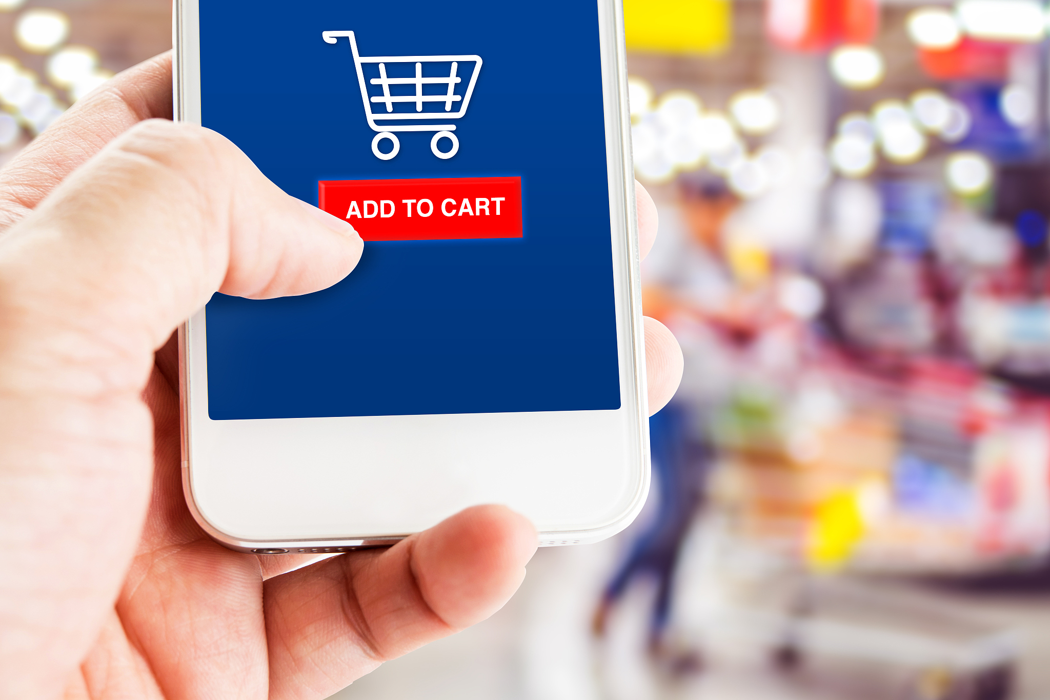 hand holding mobile with blur customer at supermarket store