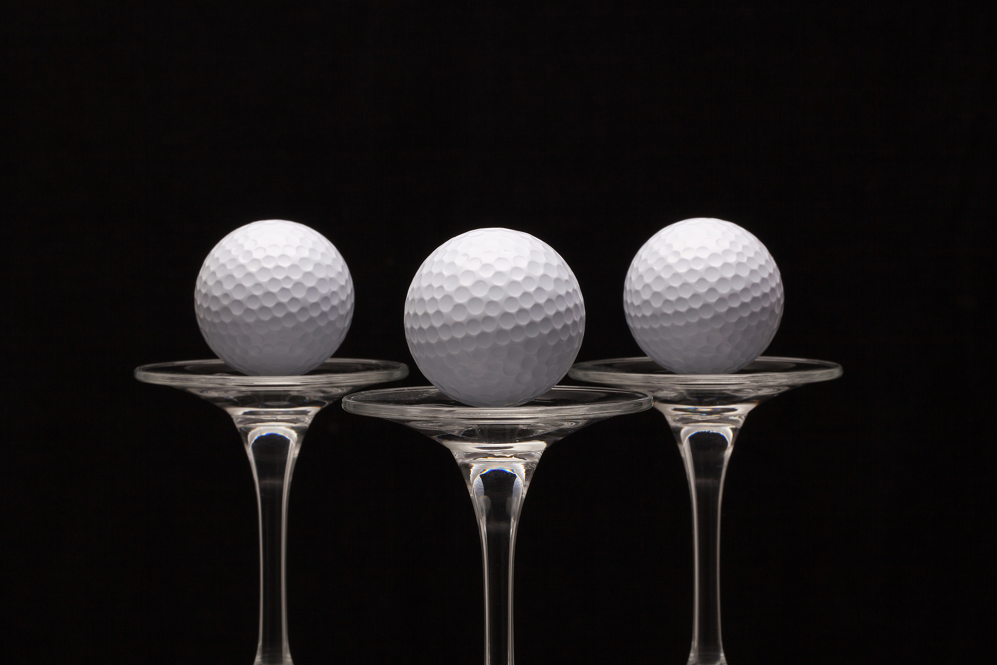 three glasses of champagne and golf balls