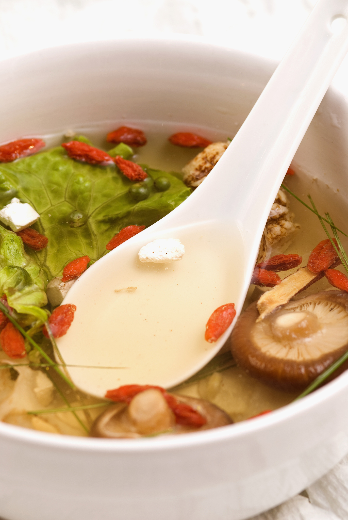 close-up of chinese soup with vegetables, mushrooms and pomegran